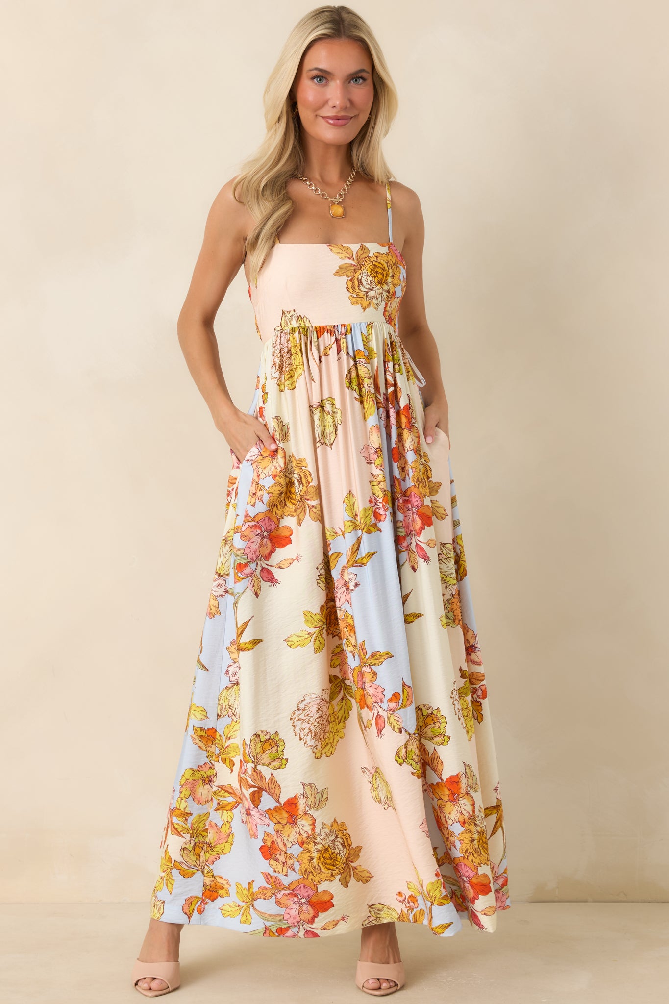 Pastel floral maxi dress featuring a softly gathered bodice, adjustable spaghetti straps, and a flowing silhouette.