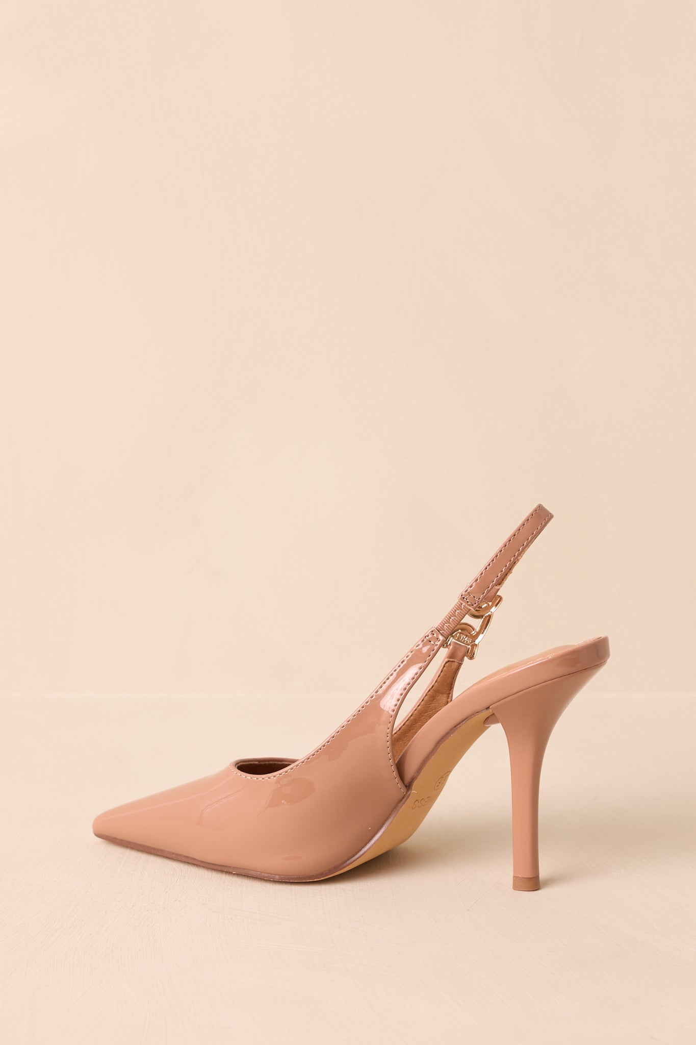 An angled shot from the side and back, showcasing the stiletto heel and patent texture.
