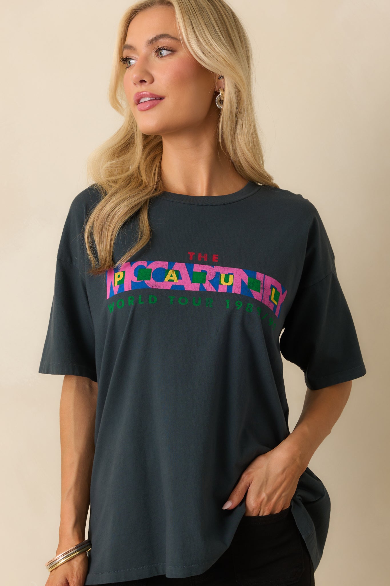 A cropped view capturing the bottom hem of the tee with the multicolor graphic visible.