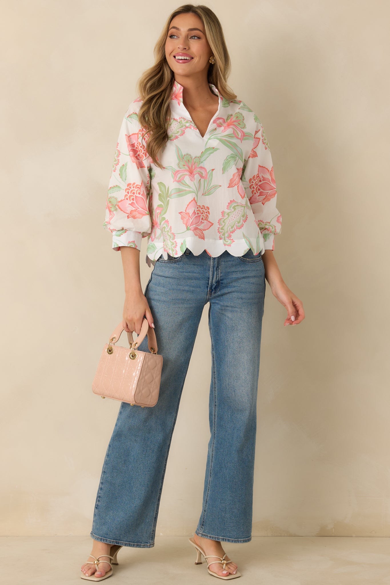 Peach multicolor top with a V-neckline, 3/4 length sleeves, and a relaxed silhouette.