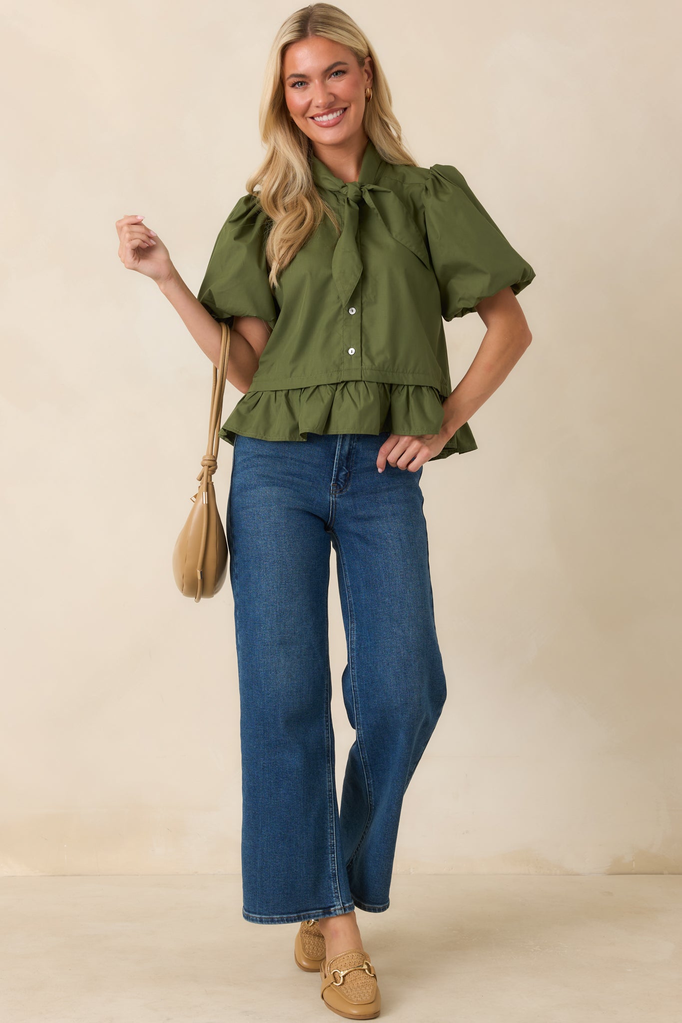 Moss green top showcasing the flounced peplum hem and polished silhouette details.
