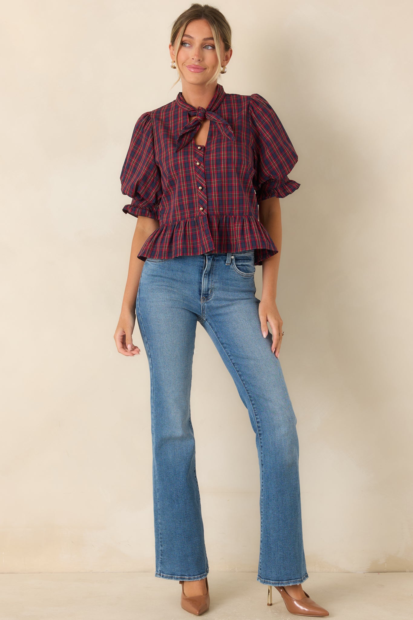 Peplum top with functional gold-tone buttons, a fitted bodice, and softly structured puff sleeves.