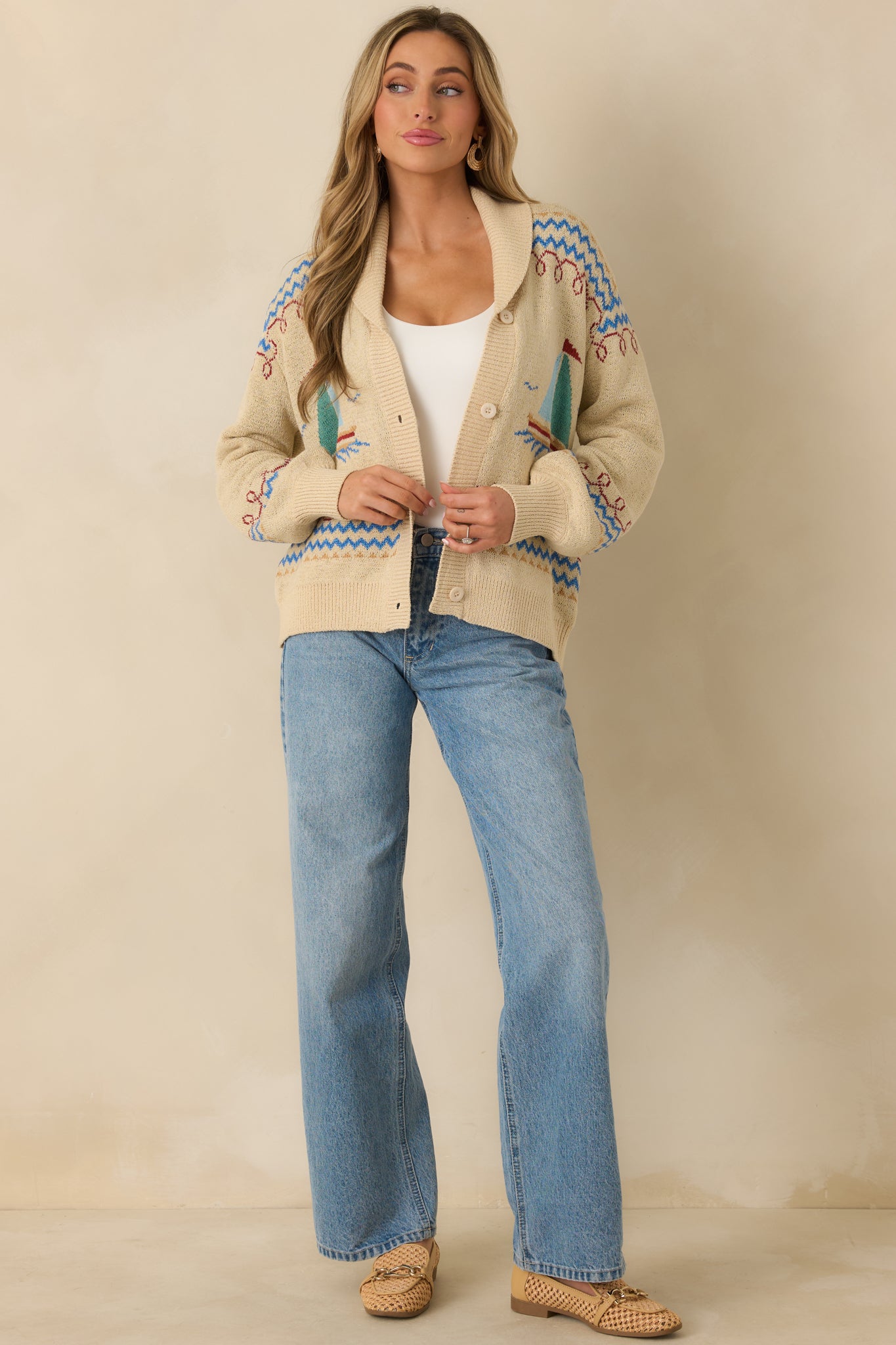 Angled front perspective highlighting the relaxed fit, ribbed trim, and sailboat motif across the cardigan.
