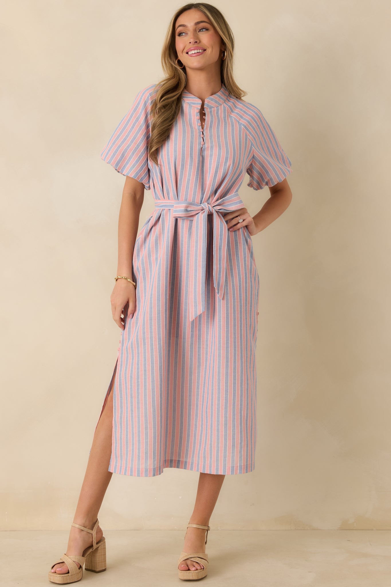 Front view of a pink and blue striped midi dress with a round neckline, short sleeves, and partial front button placket.