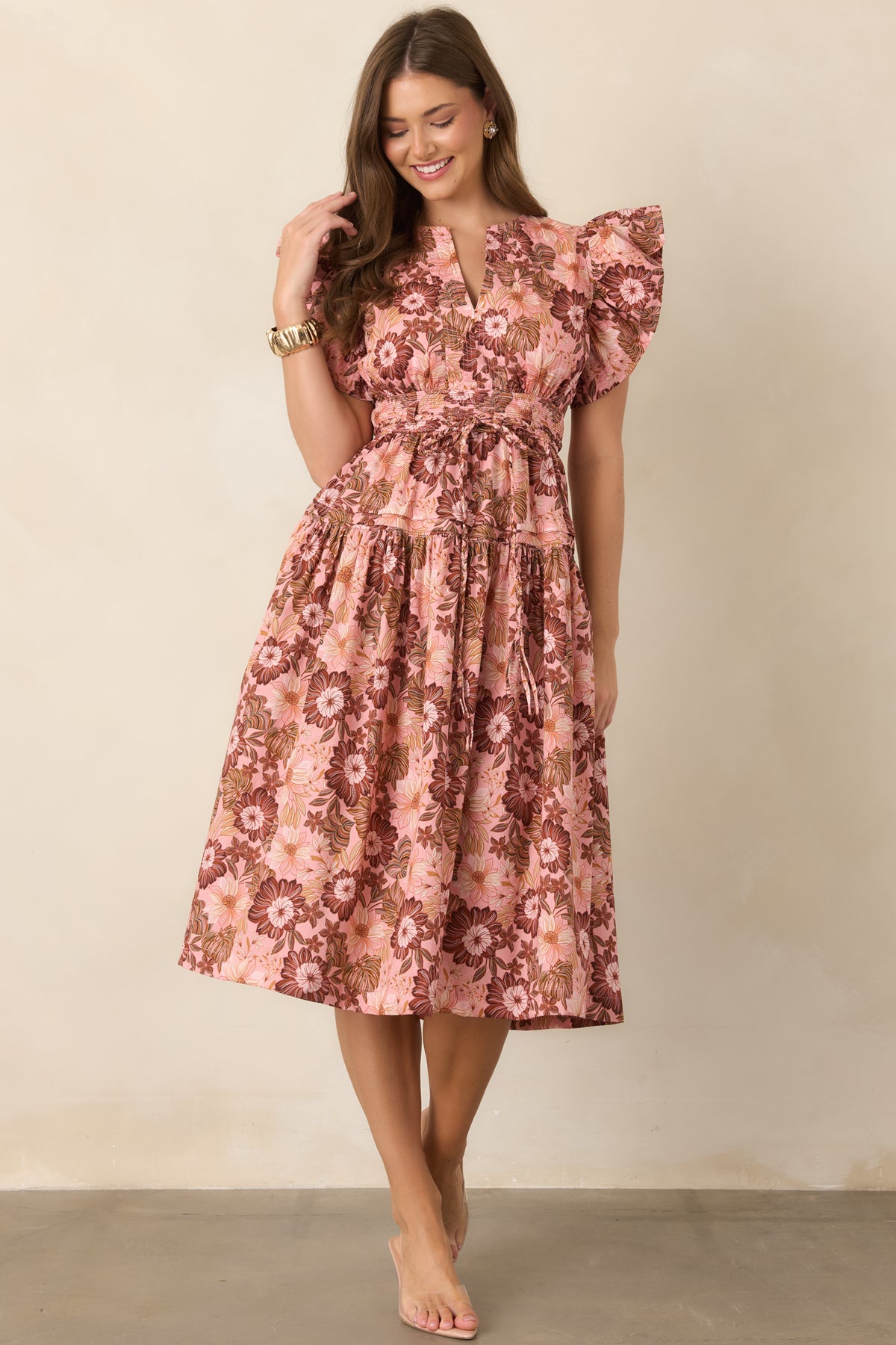 Pink and brown floral dress with delicate ruffle sleeves, a V-neckline, waist-defining silhouette, and softly gathered skirt for graceful movement.