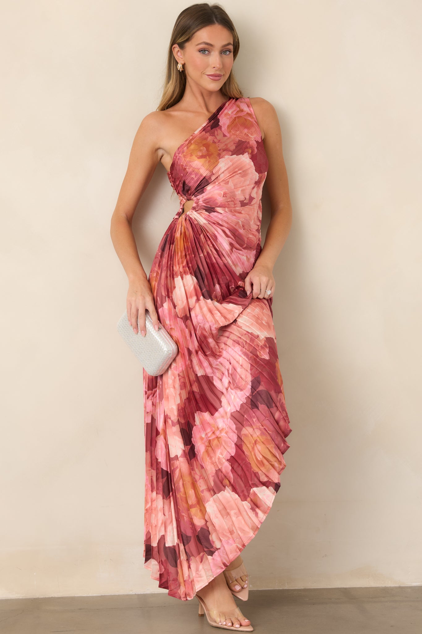 Pink and burgundy floral satin dress showcasing its one-shoulder silhouette, sculpted waist, pleated texture, and sweeping asymmetrical maxi skirt.