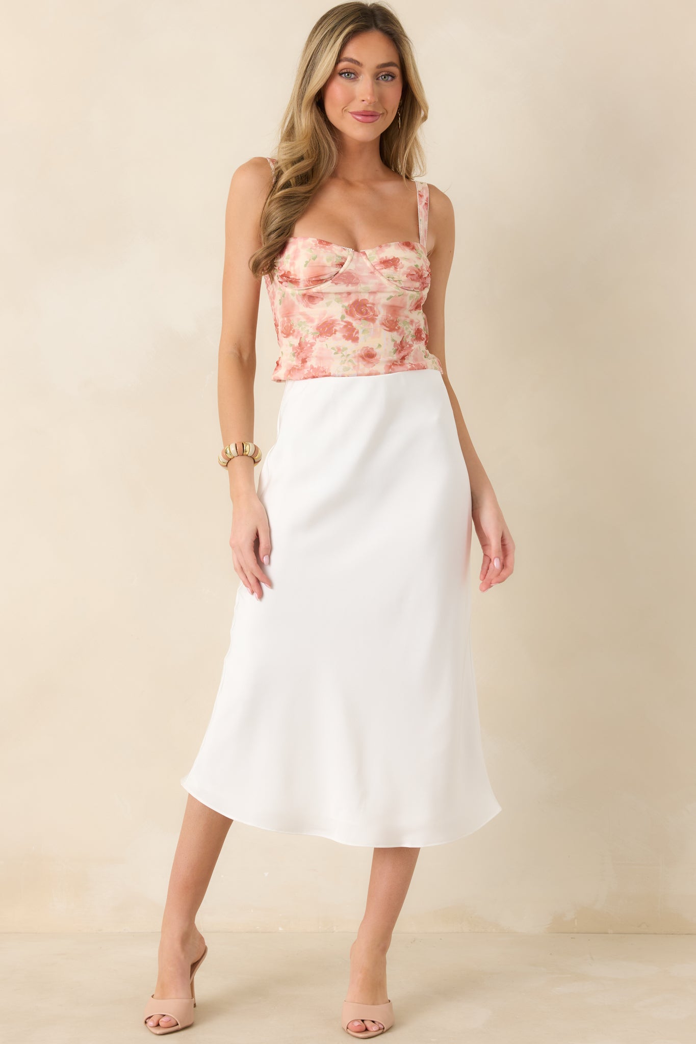 Straight-on front view of pink bustier with structured seaming, contoured neckline, and textured floral overlay.