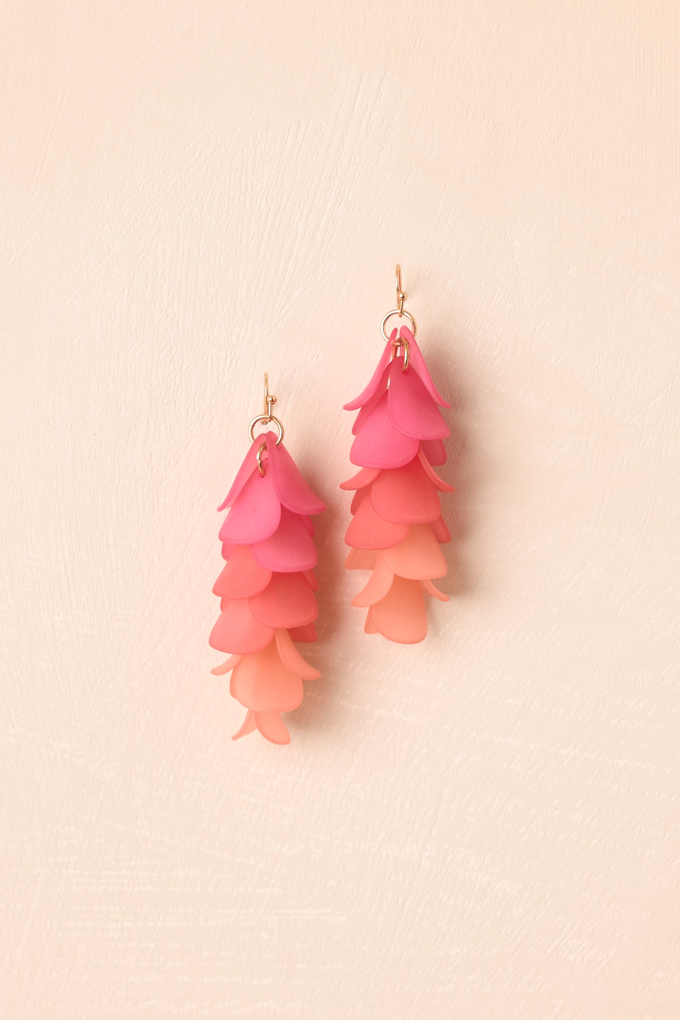 Pink and coral drop earrings featuring layered petal-like shapes and a lightweight statement design.