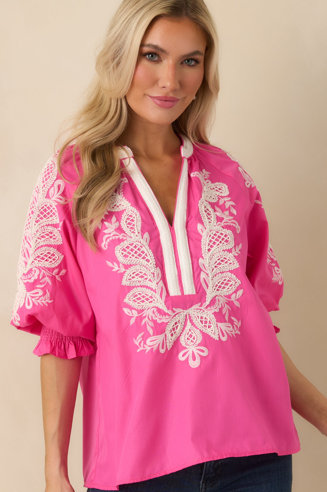 Pink embroidered fabric shown with soft puff sleeve construction and elastic cuff finish.