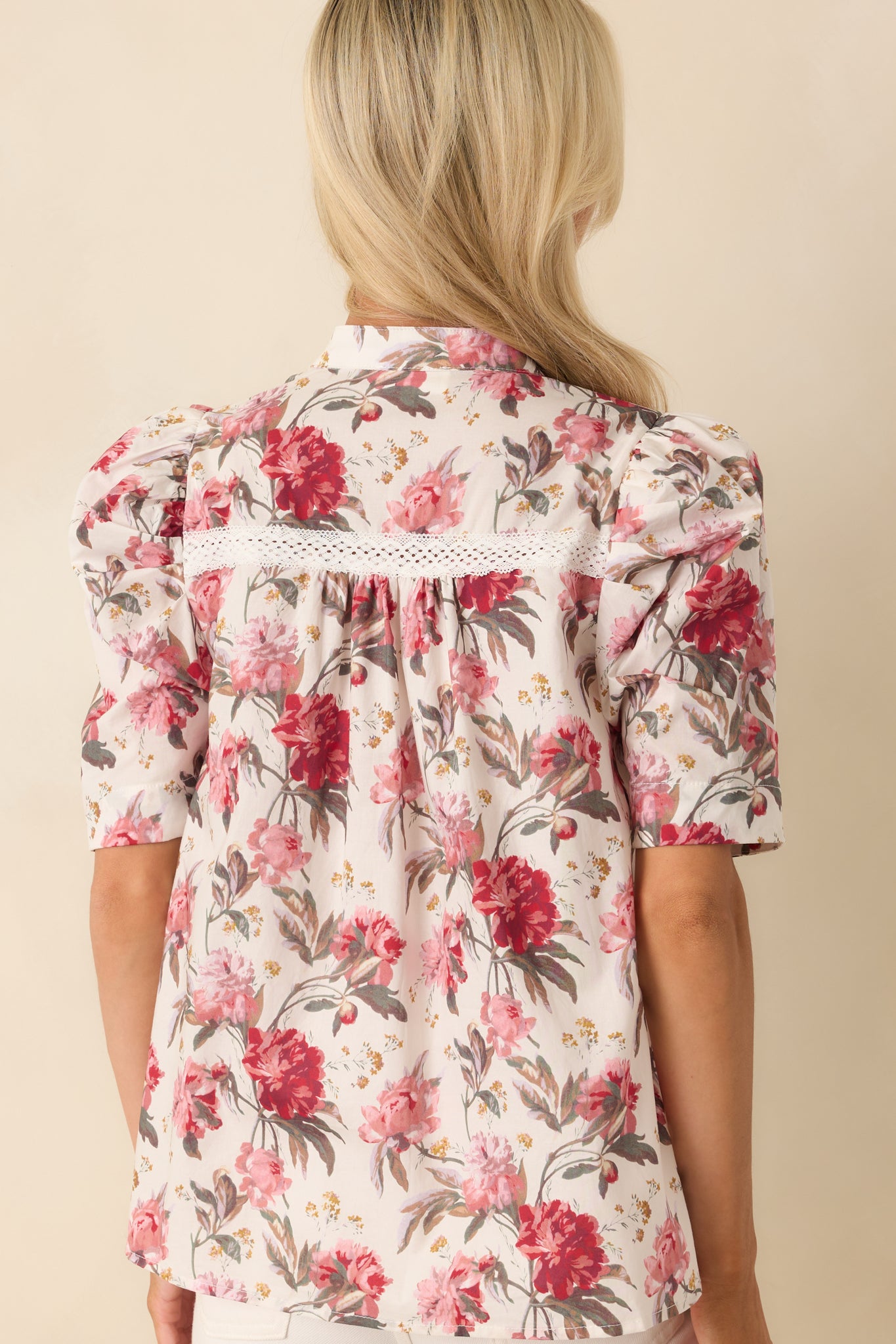 Back view of the top showing the continuous floral print and fitted neckline.