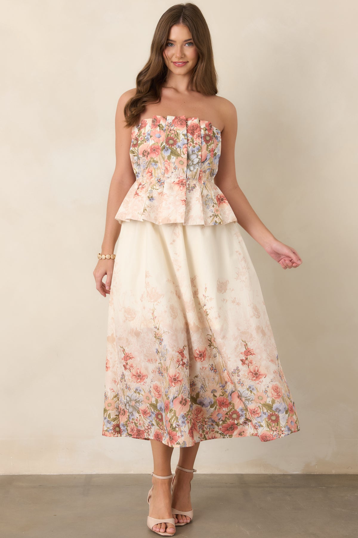 Feminine pink floral dress featuring a clean strapless neckline, pleated bodice, elasticized waist, and gracefully draped midi-length skirt.