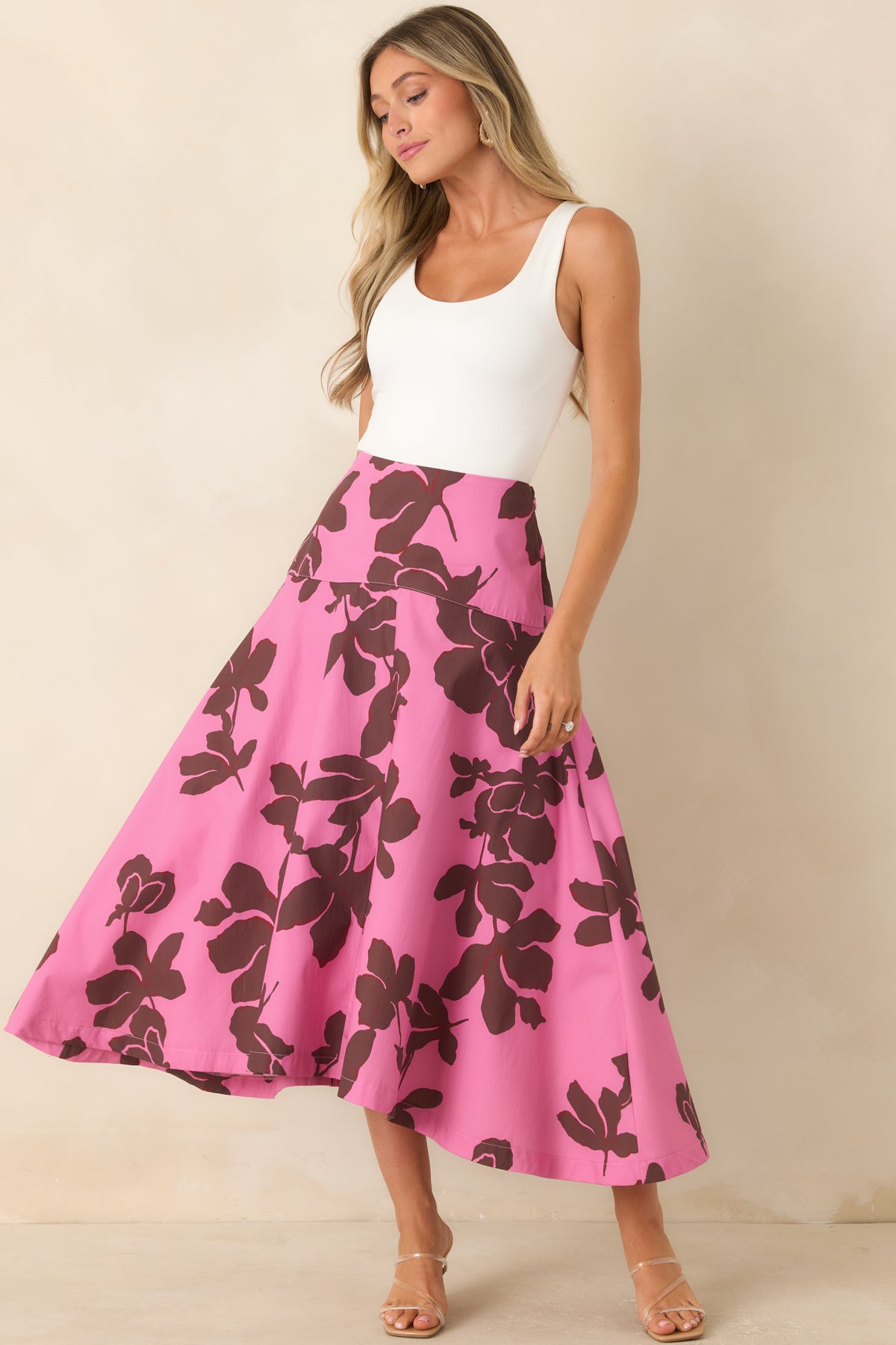 Pink midi skirt featuring oversized chocolate brown florals, a wide fitted waistband, concealed side zipper, and voluminous A-line silhouette.