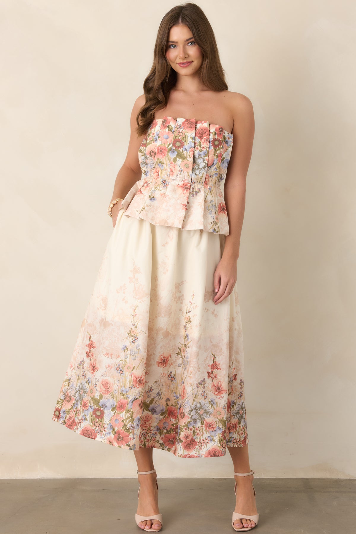 Pink multi-floral cotton midi dress highlighting its strapless pleated bodice, elasticized waist, flowing skirt, and relaxed feminine silhouette.