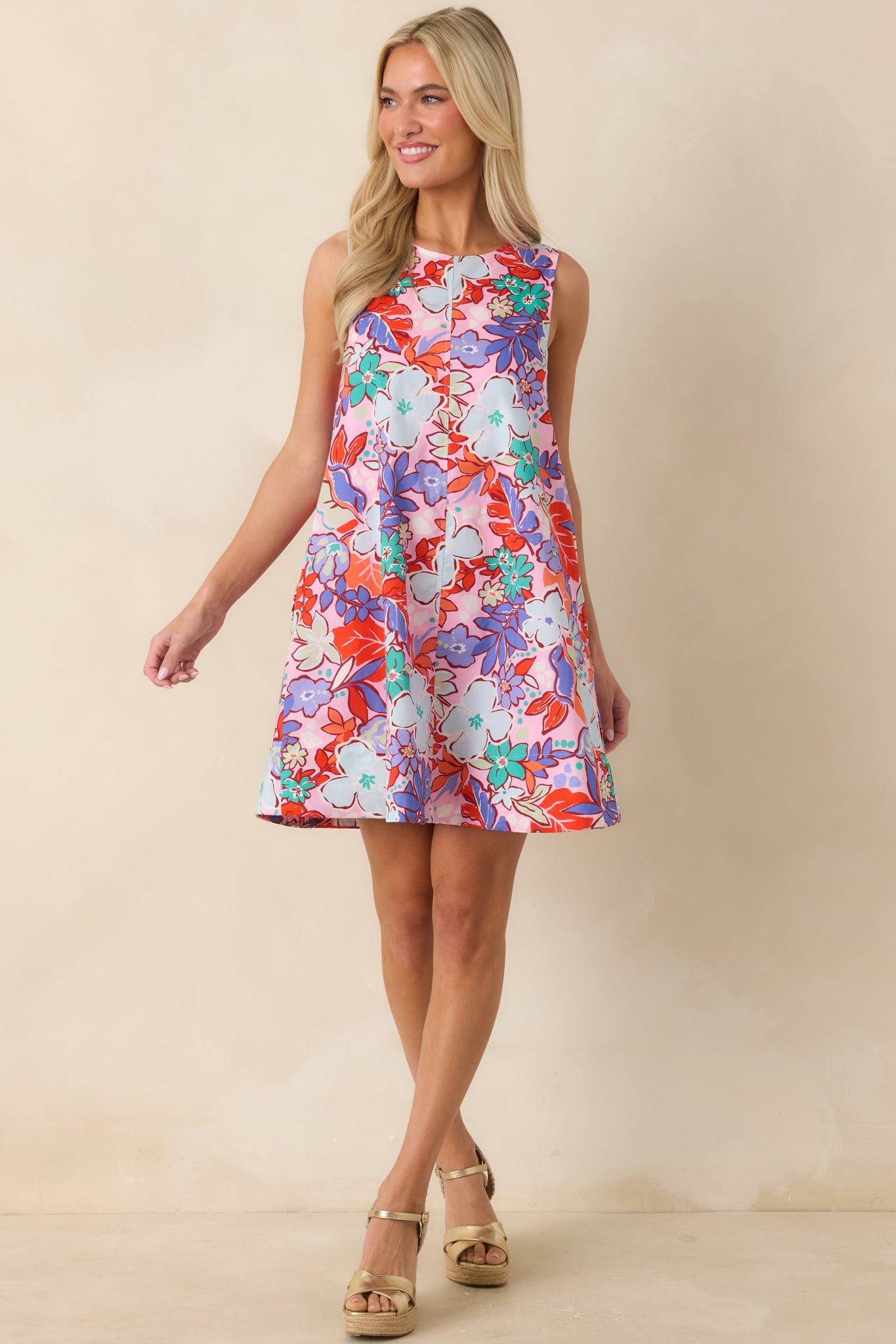 Pink multi floral dress with an effortless swing silhouette, breezy fabric, hidden pockets, and a playful colorful print throughout.