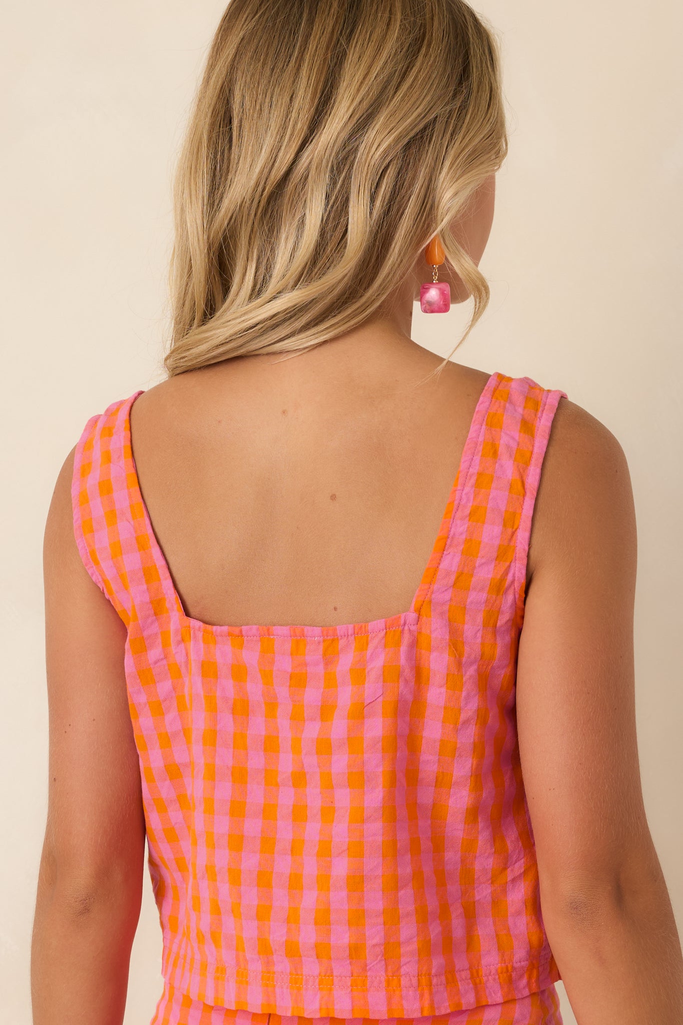 Rear view of the pink and orange plaid cropped cotton tank featuring wide shoulder straps and a clean, easy pull-on silhouette.
