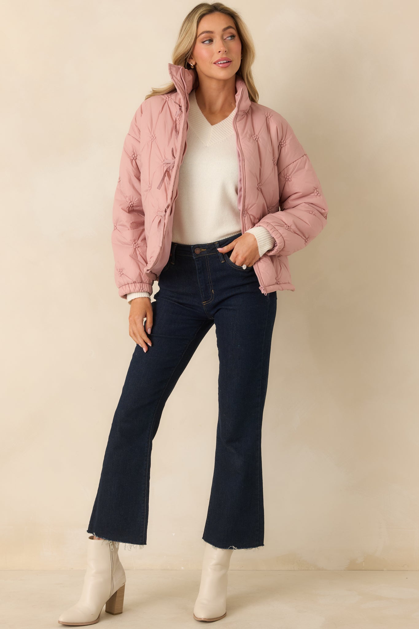 Lightweight blush pink puffer jacket featuring long sleeves, elasticized cuffs, and subtle front tie accents for added detail.