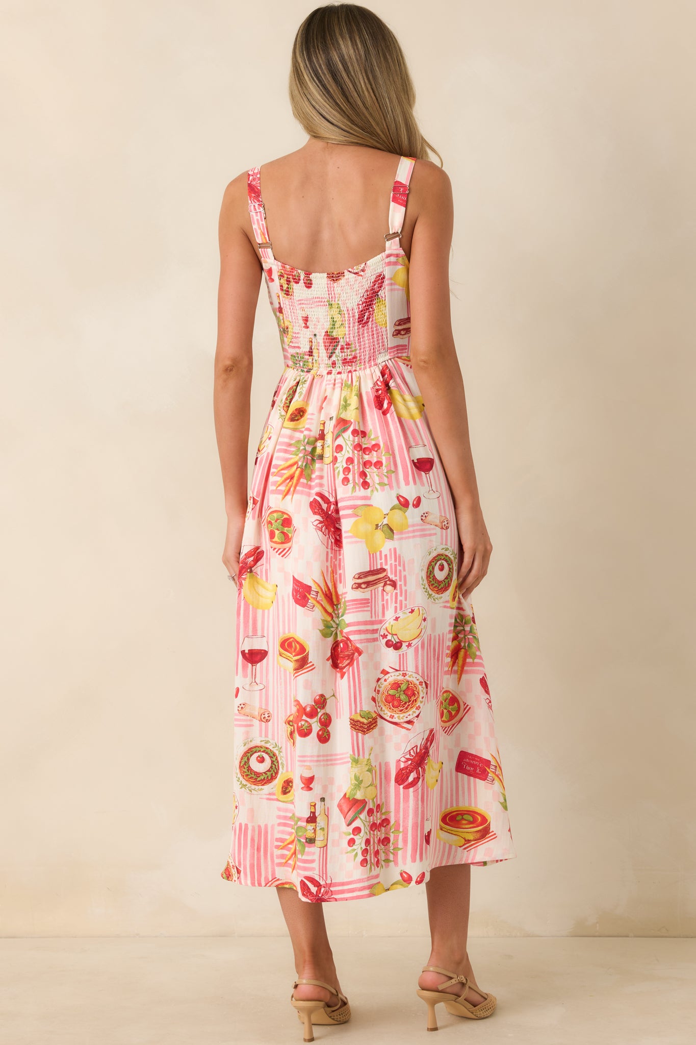 Pink striped midi dress showing the back of the flowy silhouette with adjustable shoulder straps and allover novelty food print.