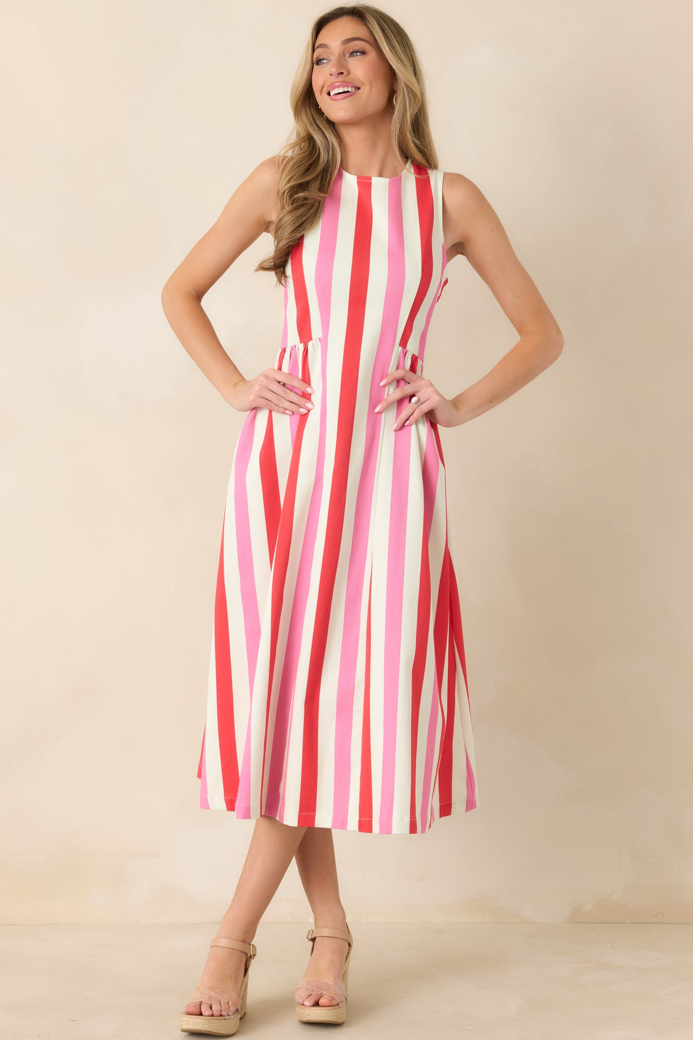 Front-facing angle of pink striped midi dress highlighting defined waist seam and structured cotton fabric.