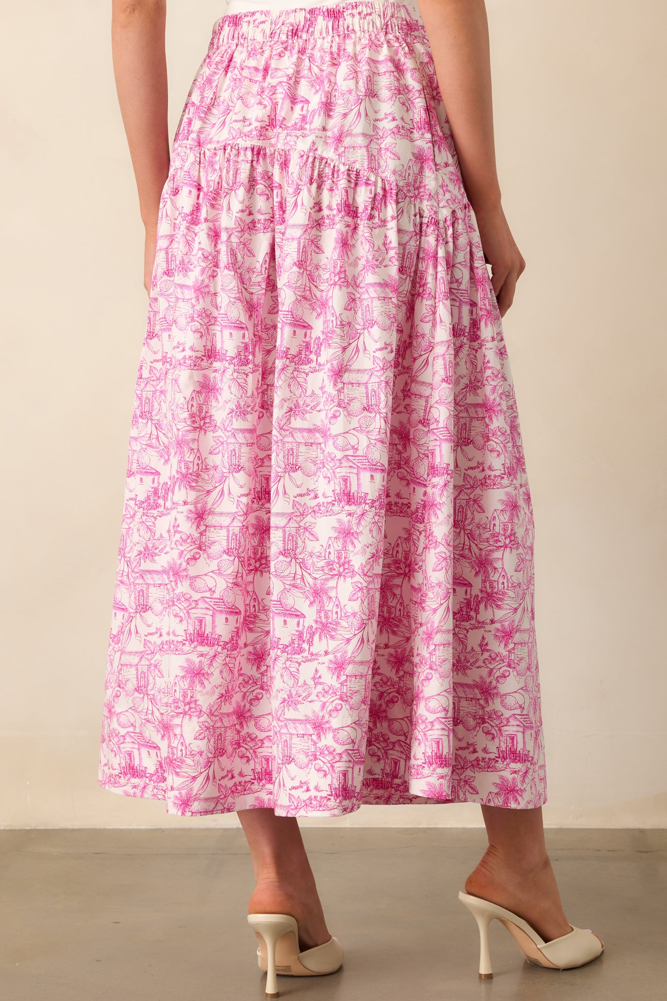 A view from behind of the pink toile maxi skirt showing the back elastic waist insert and flowing hem.