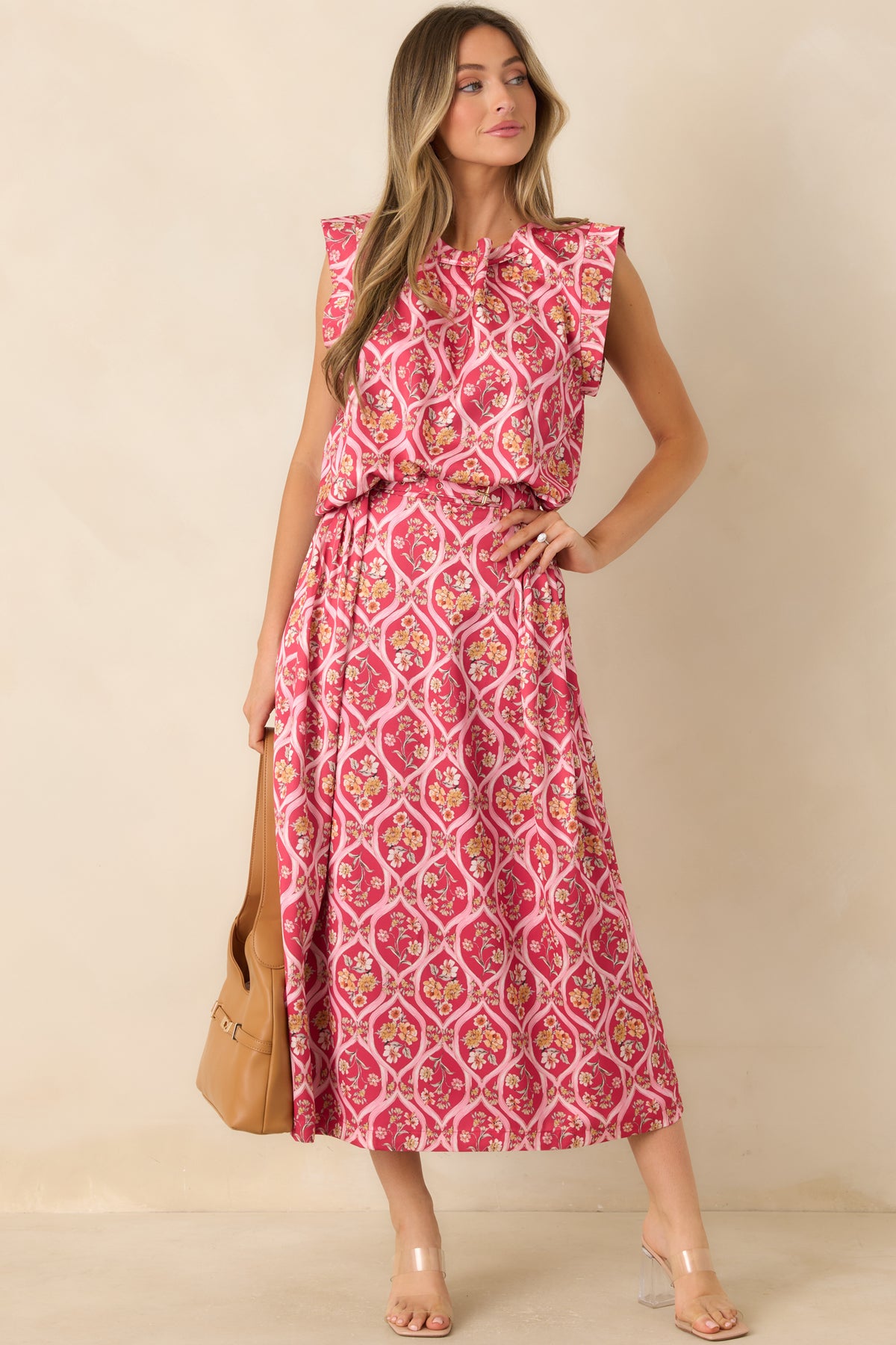 Pink trellis-print top with ruffled shoulder details, an adjustable neckline, and a softly gathered hem.