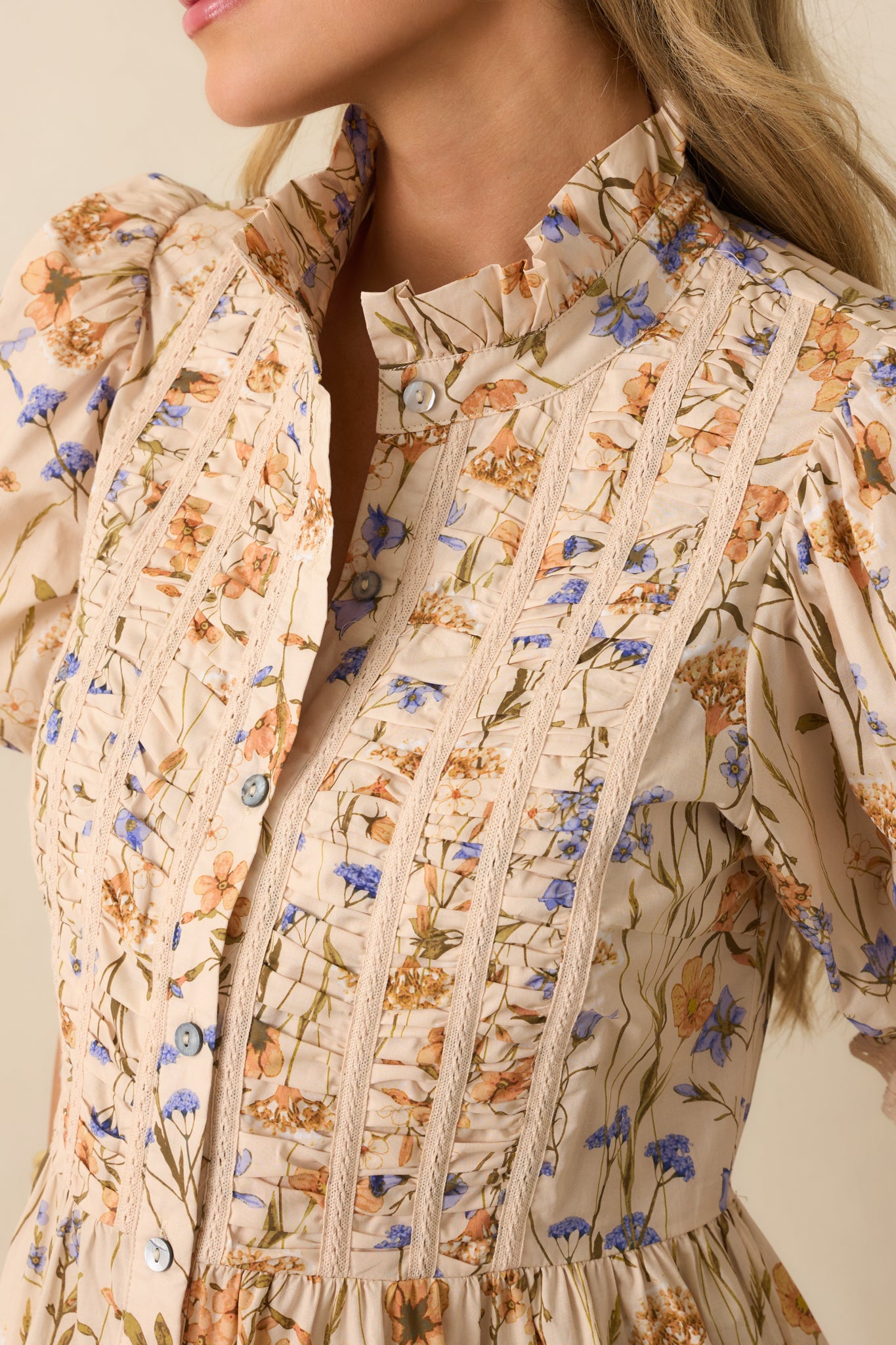 Detailed shot of pintuck and lace trim detailing with floral print fabric.