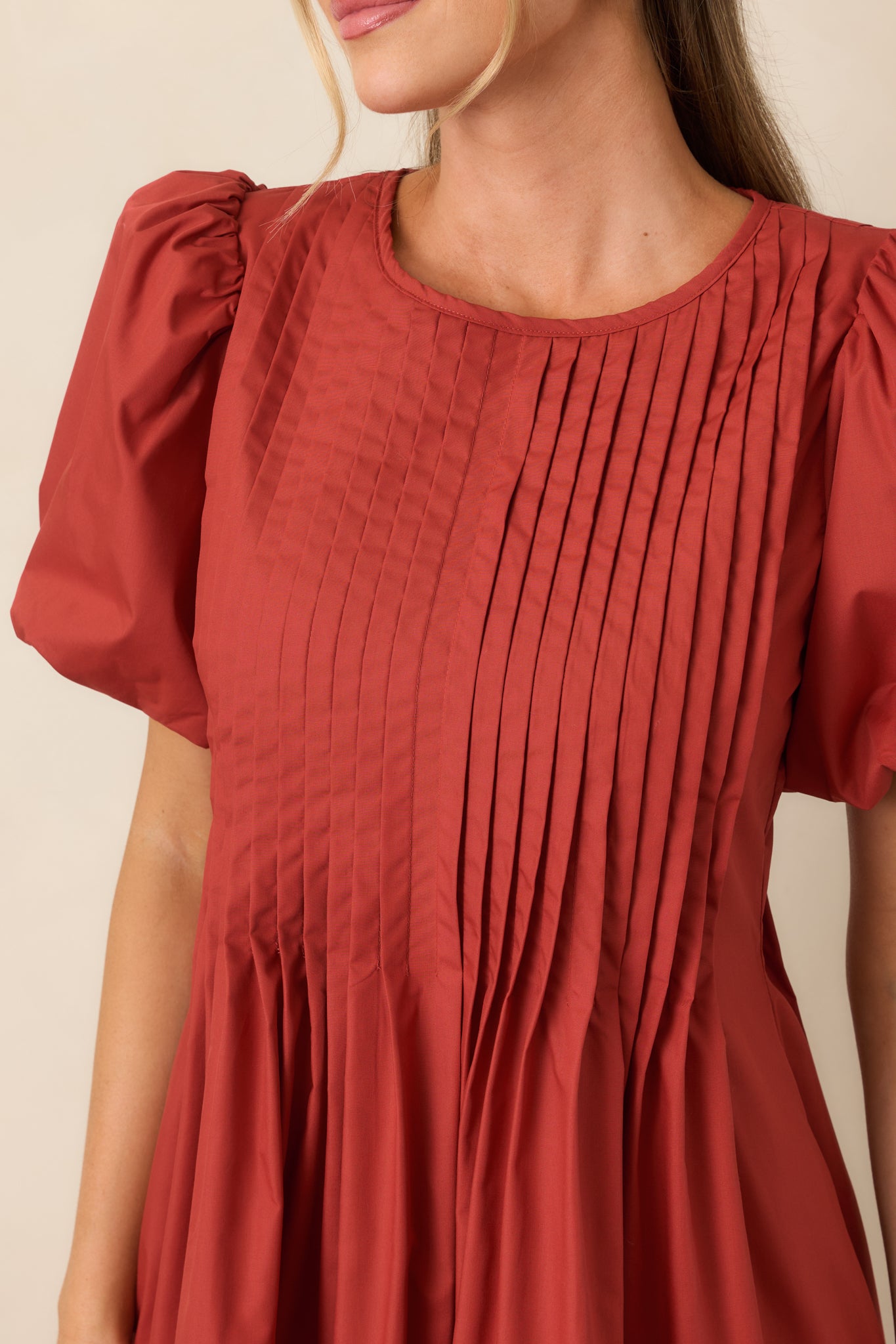 Close-up highlights the precise pintucking across the bodice, delicate sleeve volume, and textured fabric finish.