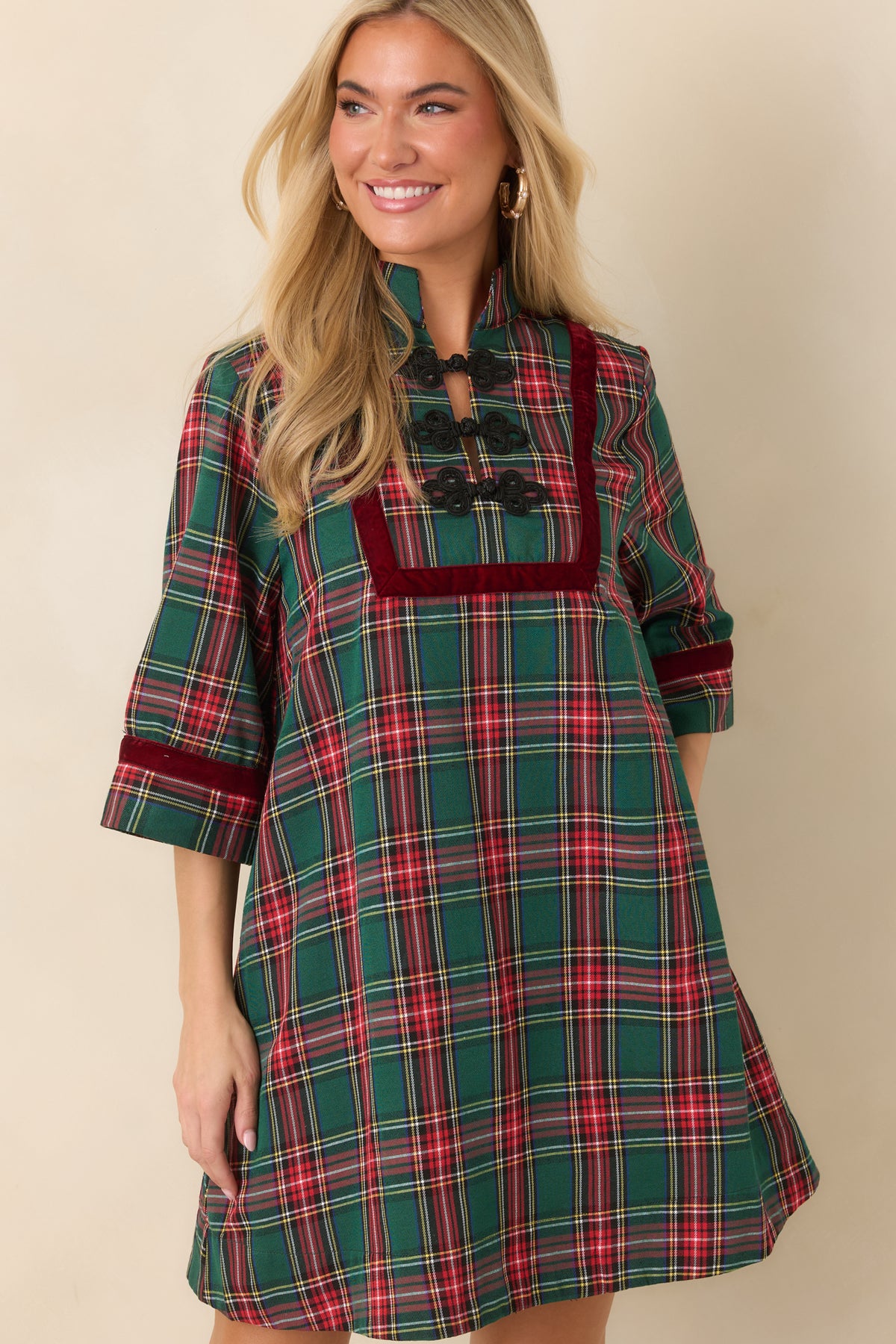 Black braided frog closures arranged along the velvet-trimmed front panel of the plaid dress.