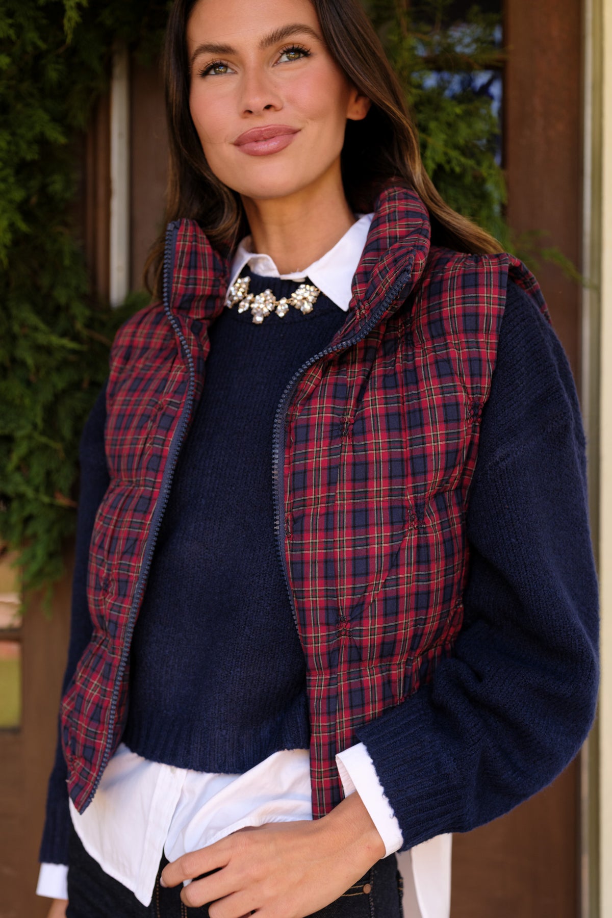 Rounded quilted stitching creates a textured pattern across the plaid vest.