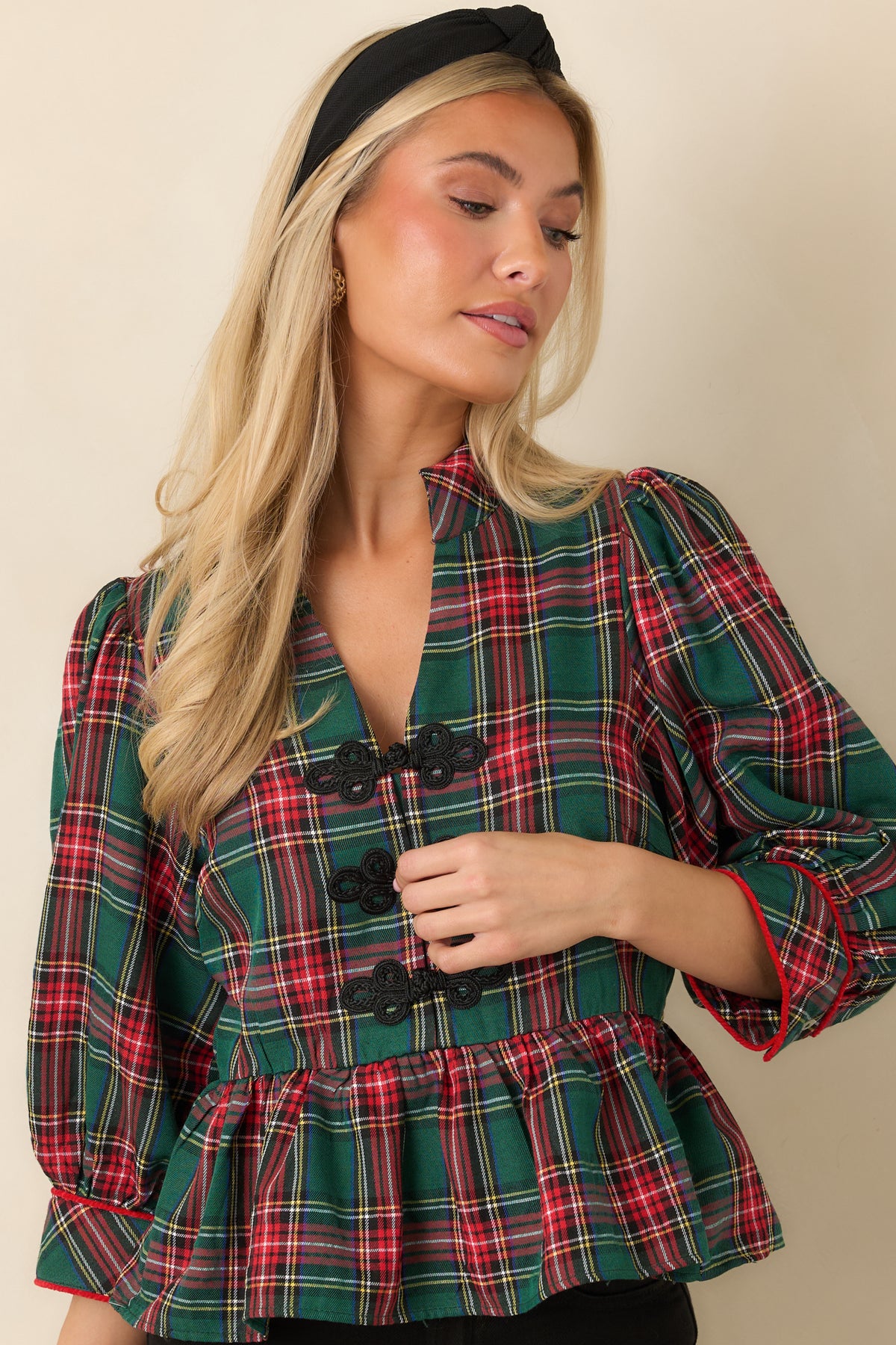 Three-quarter puff sleeves on a plaid top with buttoned cuffs and contrasting red piping.