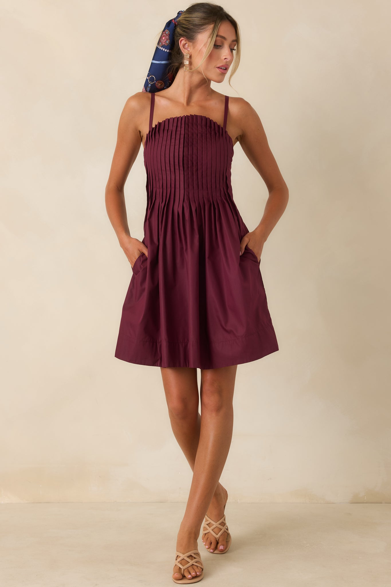 Mini dress featuring a pleated bodice, gathered skirt, adjustable straps, and a flattering fit-and-flare silhouette.