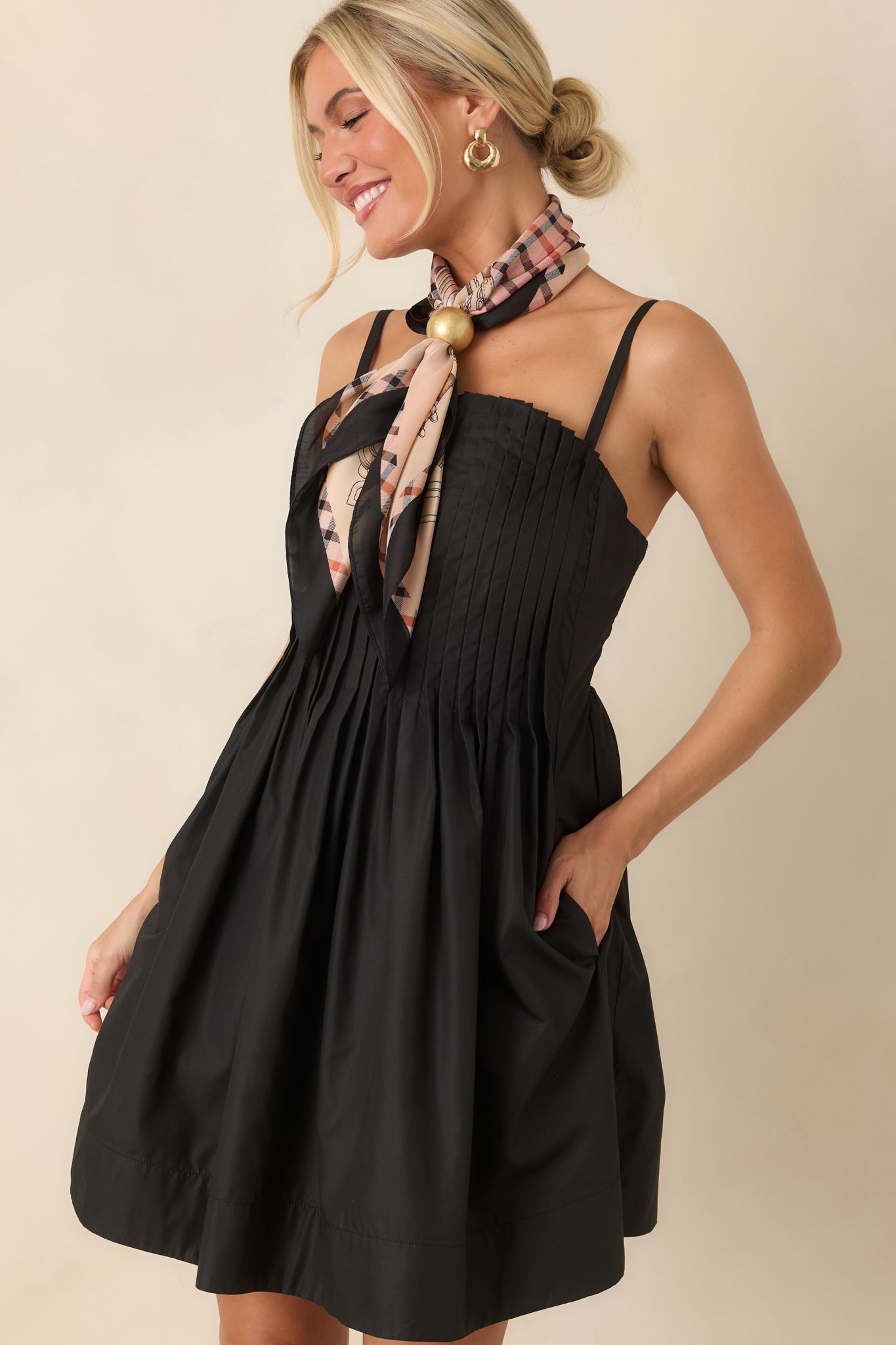 Detailed view of the pleated bodice texture and adjustable shoulder straps on the black dress.