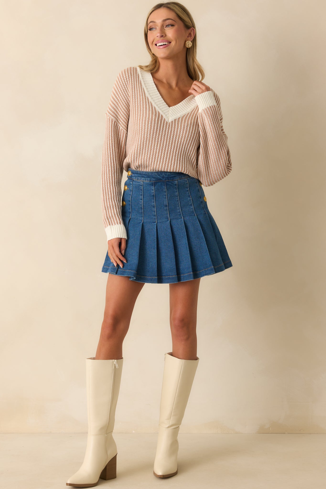 Pleated dark wash skirt with gold button accents along the sides and relaxed silhouette.