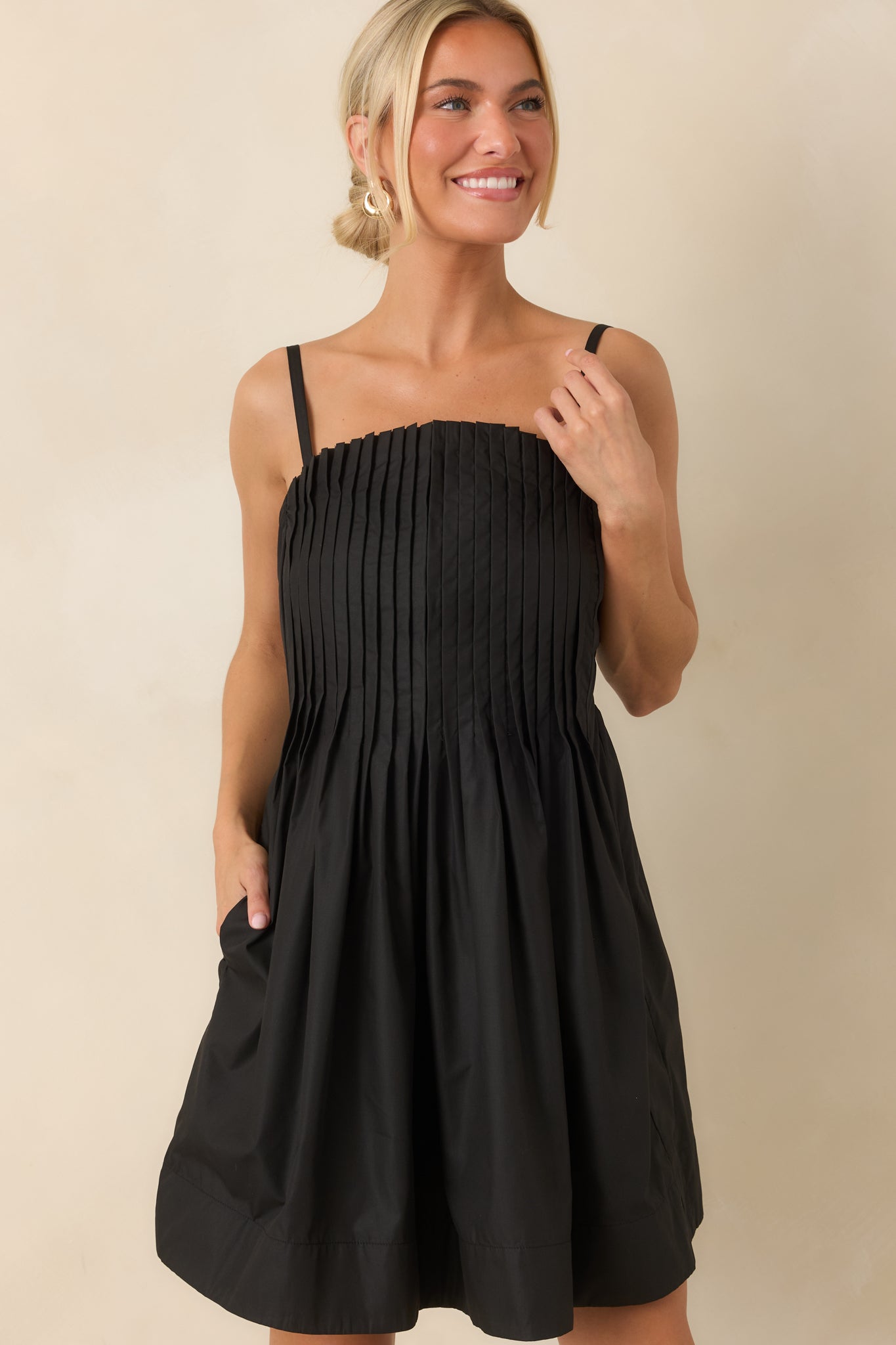 Pleated dress detail featuring the elegant bodice structure and smooth fabric finish.