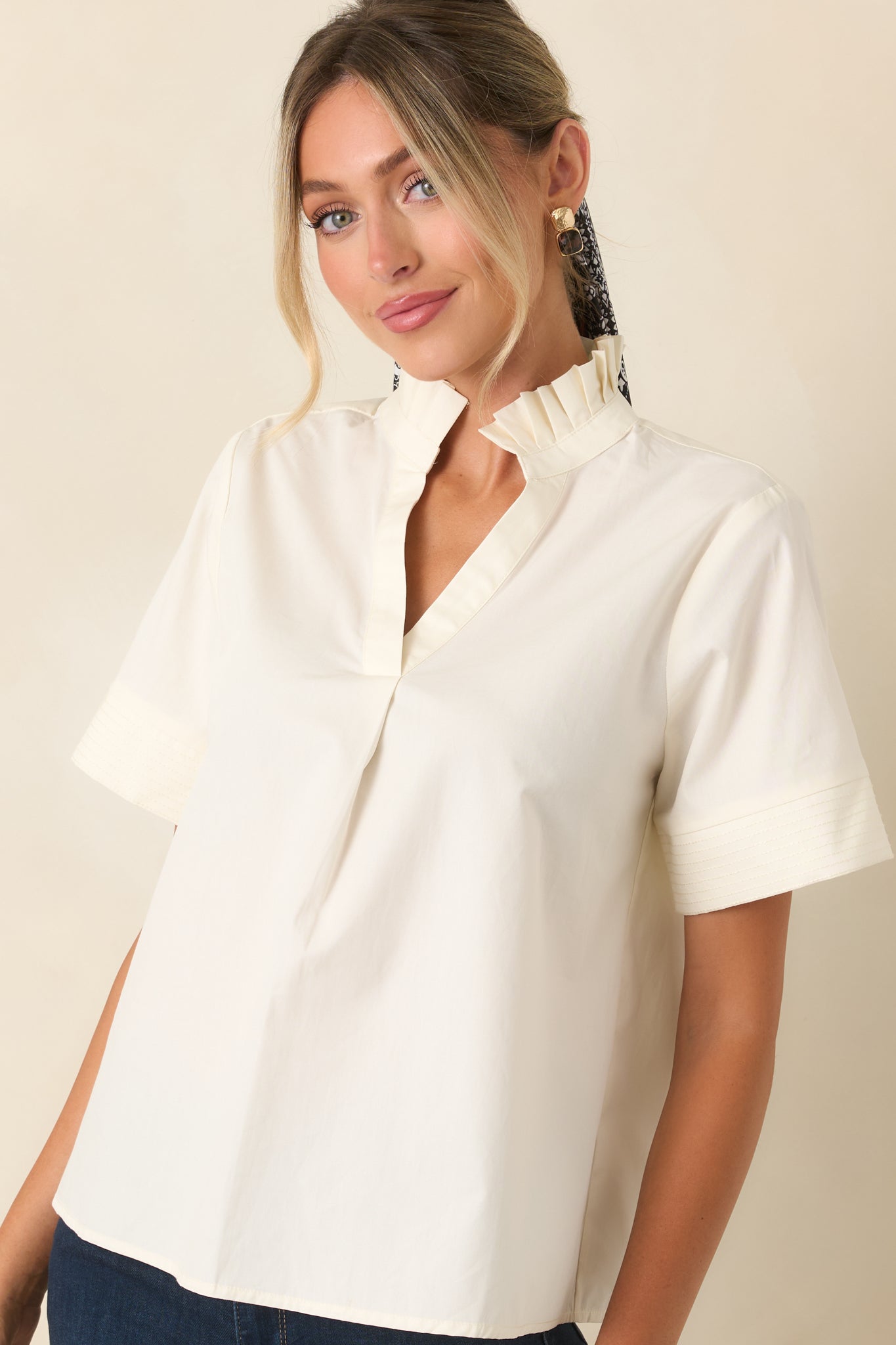 Pleated ruffle collar frames the split neckline with soft texture and feminine detail on this cotton top.