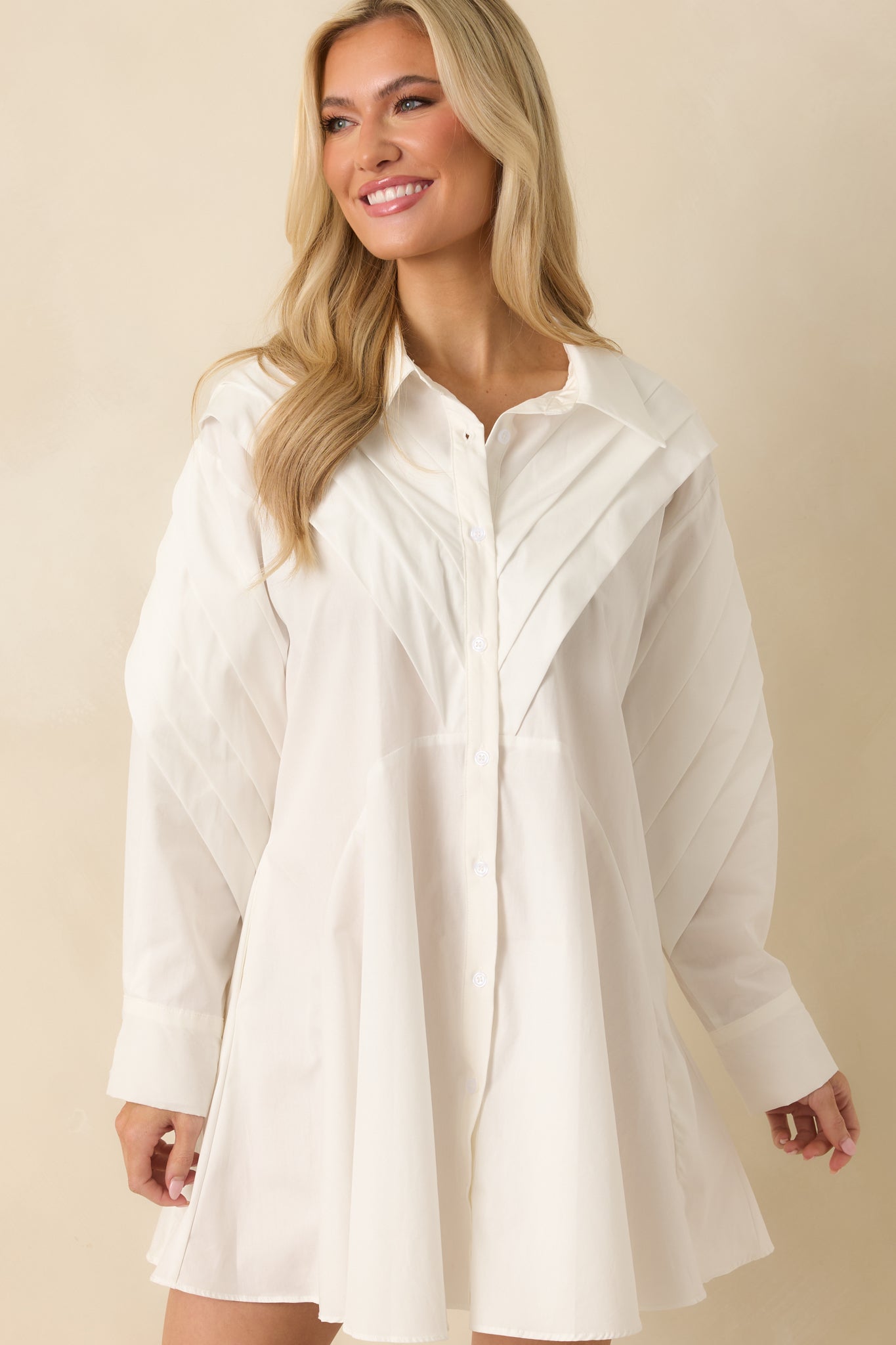 Pleated texture and smooth woven fabric highlighting the dress’s design.