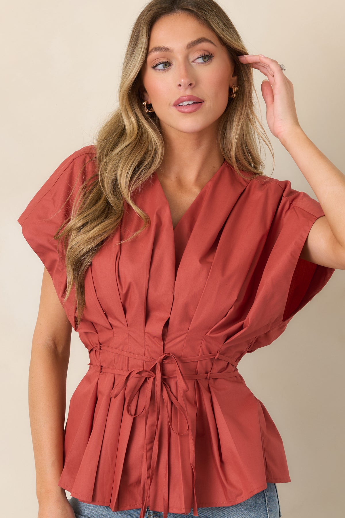 Pleated top with a defined V-neckline, softly shaped sleeves, and slender ties that cinch the waist.