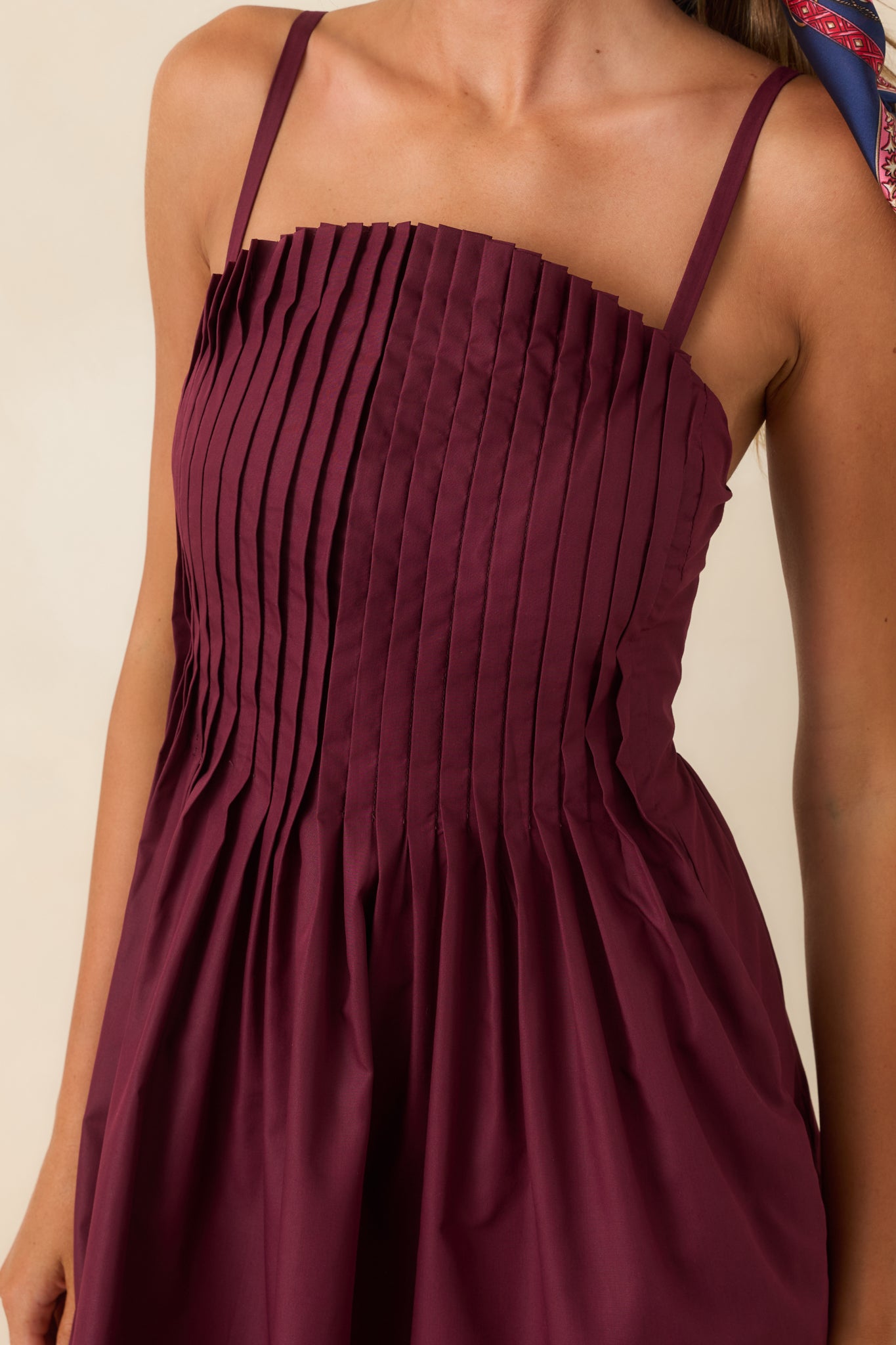Close-up view of the mini dress highlighting the intricate pleating, woven texture, and fabric details.