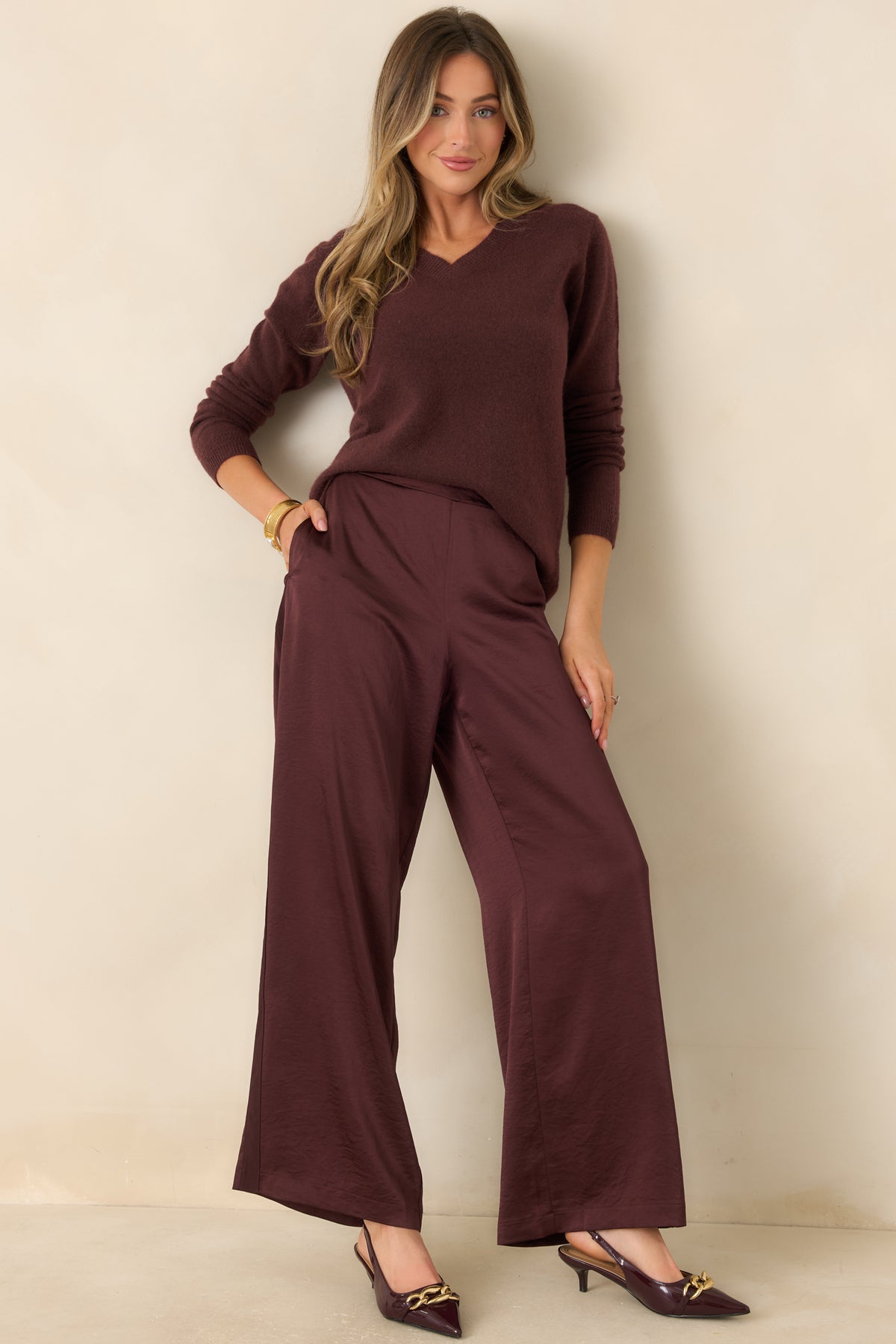 Deep plum-brown sweater featuring a soft wool-blend knit, long sleeves, and ribbed finishing along the hem.