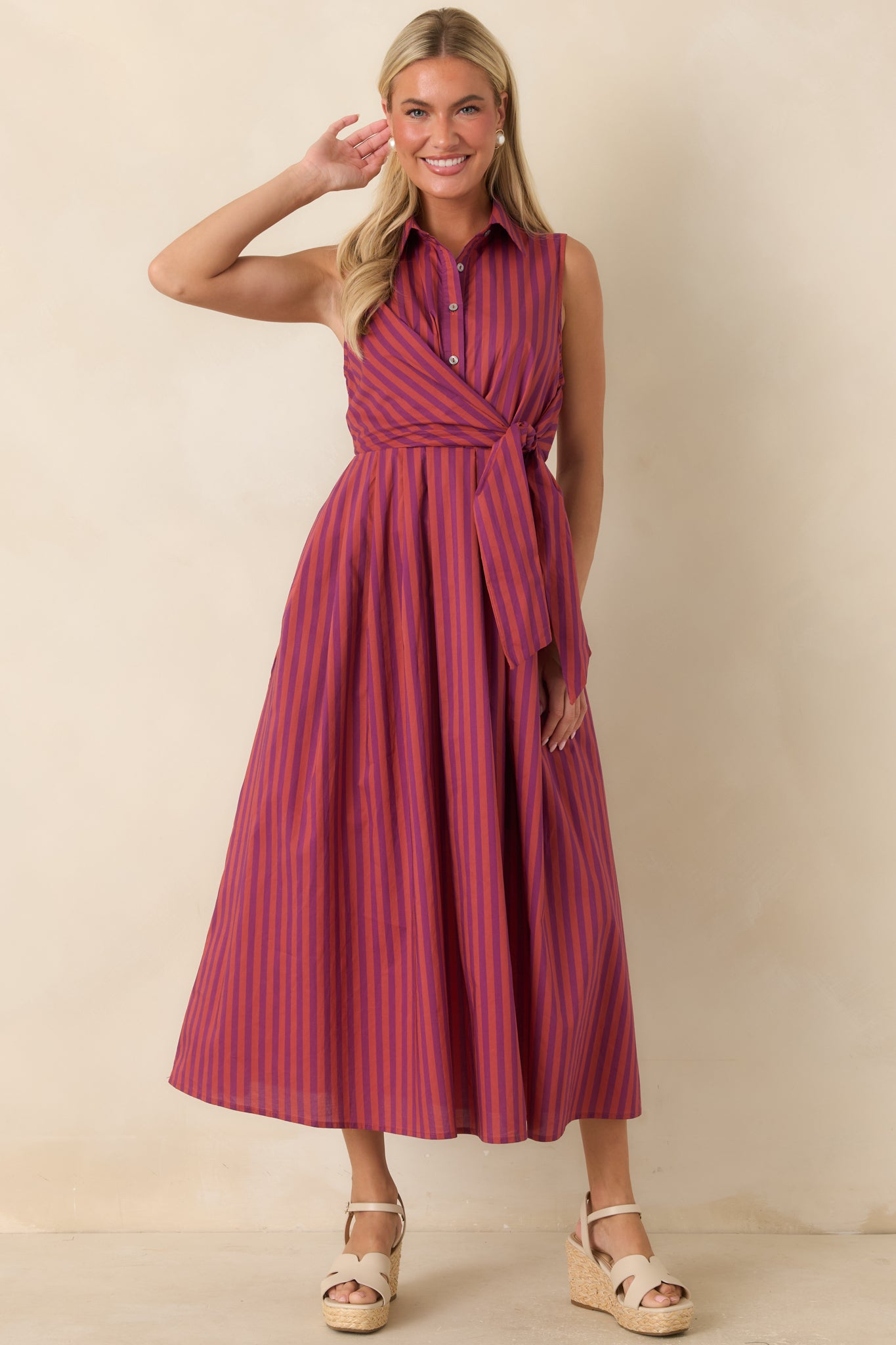 Plum and burgundy striped cotton midi dress featuring a pointed collar, button-front bodice, front tie waist, and flowing A-line skirt.