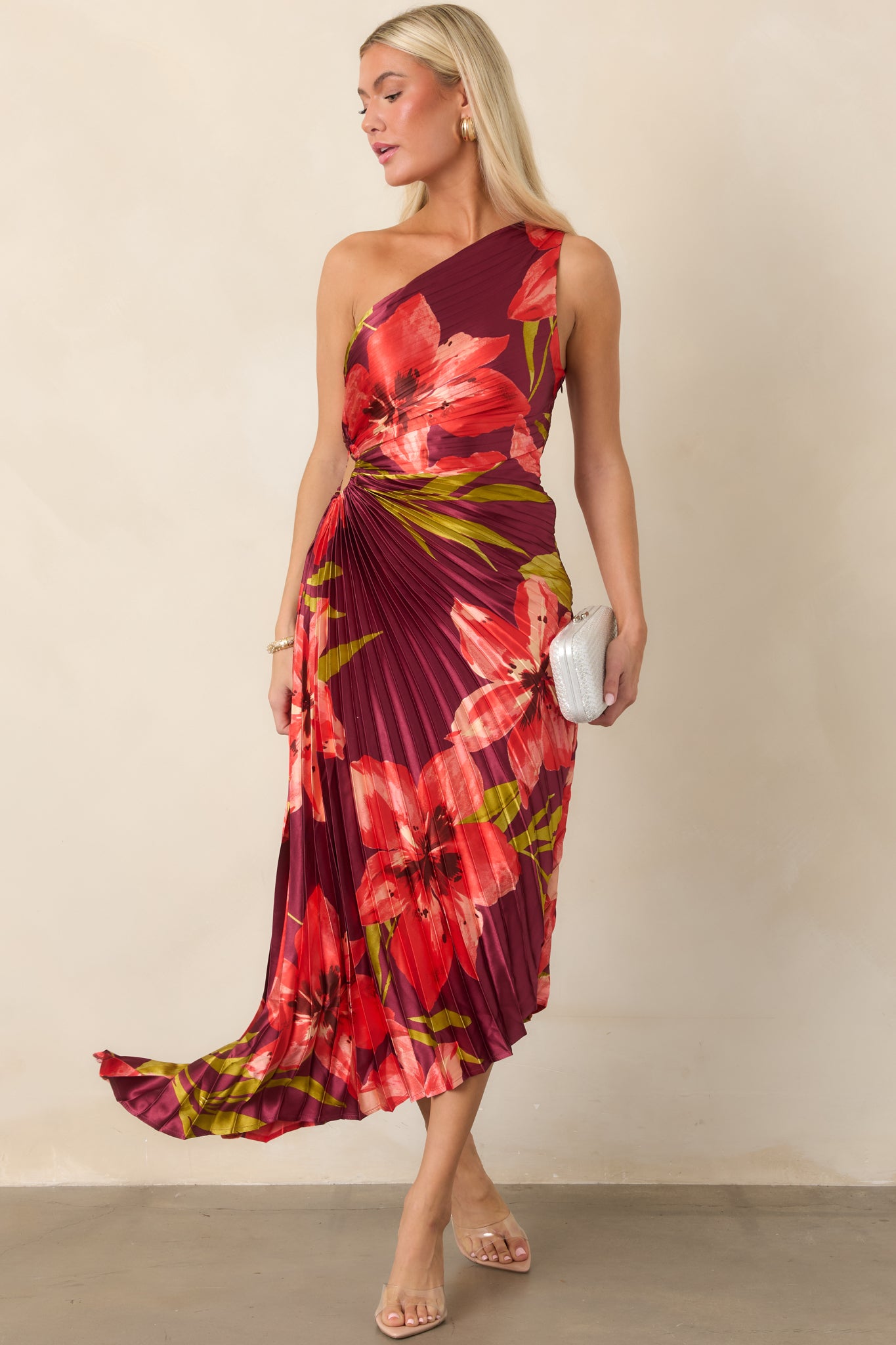 Satin midi dress with vibrant hibiscus blooms, a defined waist cutout, and flowing high-low hem for dramatic movement.