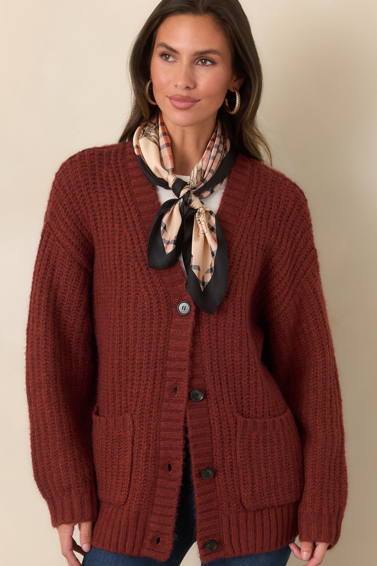 Plush knit cardigan highlighting the open V-neckline, dark button front, and wide ribbed neckline trim.