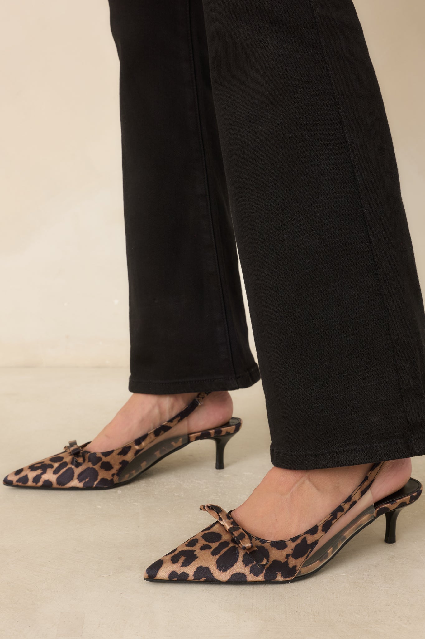 Pointed toe slingback heels with a leopard print finish, clear side panels, and a refined kitten heel.