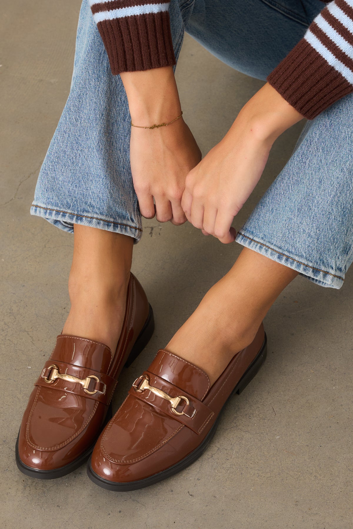 Polished brown loafers showcasing the shiny patent finish and classic slip-on construction.