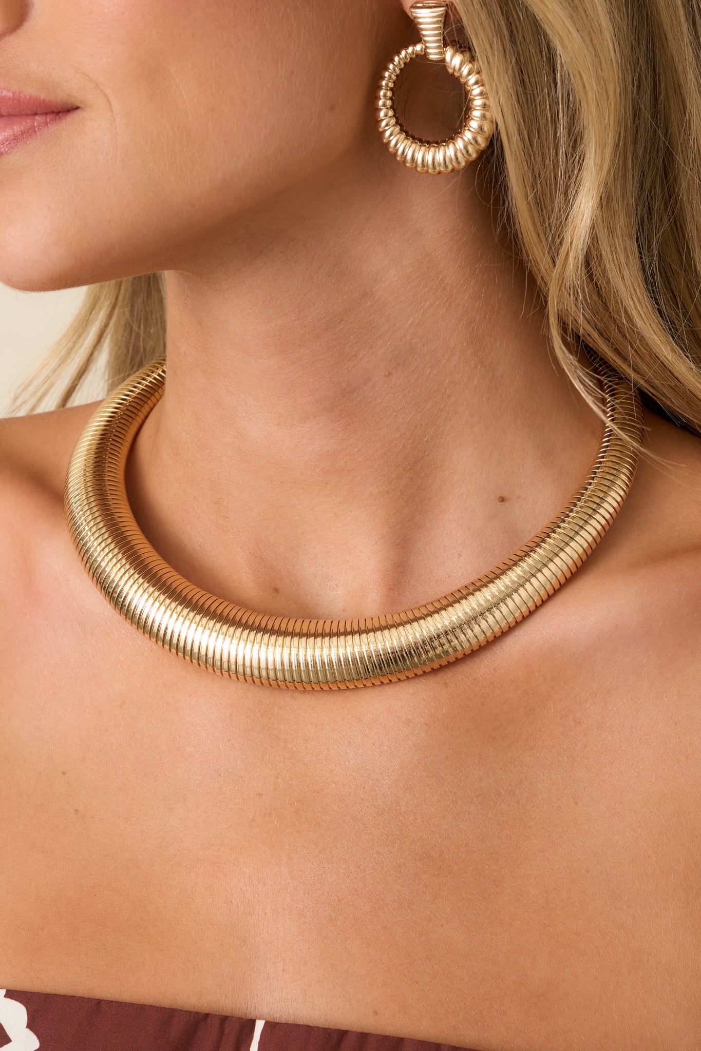 Close view of the necklace showcasing the polished gold finish, textured ribbed detailing, and fuller center design for a dimensional look.
