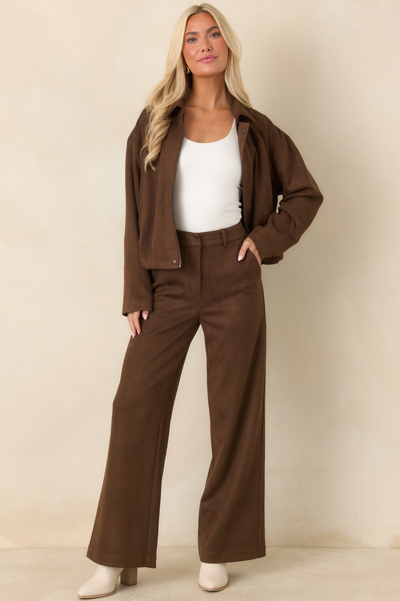 Refined wide-leg pants with a structured high-rise front, smooth concealed closure, side pockets, and flowing full-length legs.