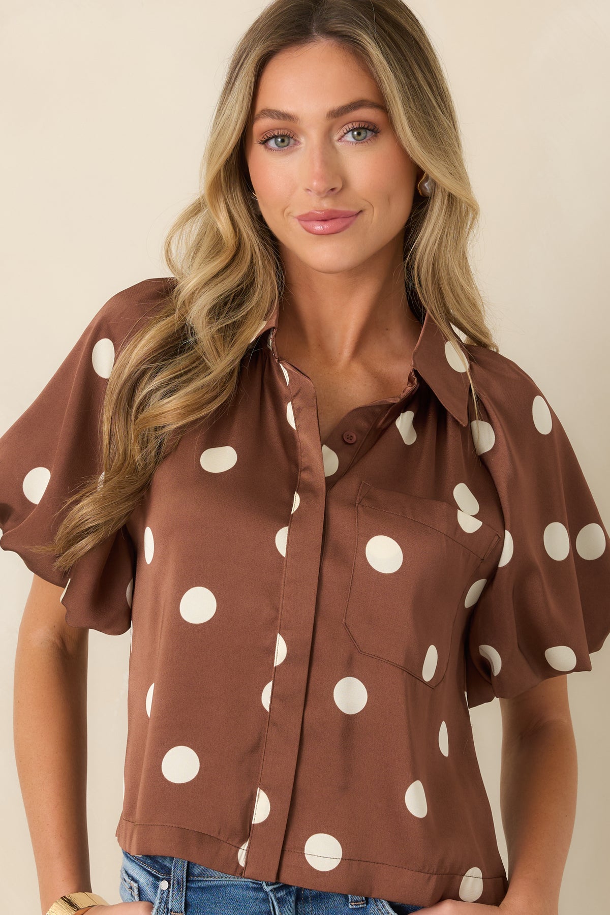 Zoomed-in look at the blouse featuring the front chest pocket, smooth woven fabric, and refined details.
