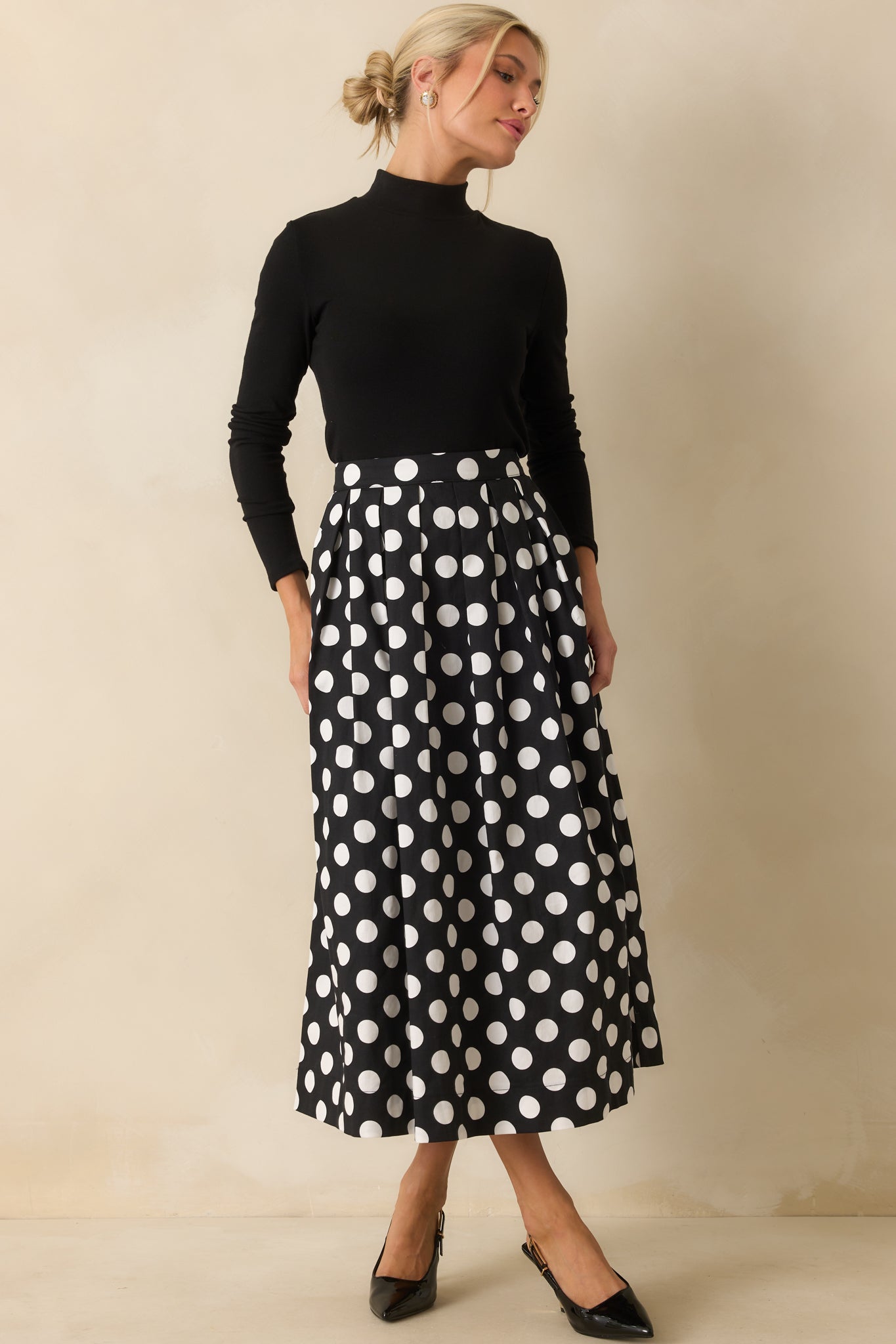 Polka dot maxi skirt featuring a flowing pleated design and structured high waist.