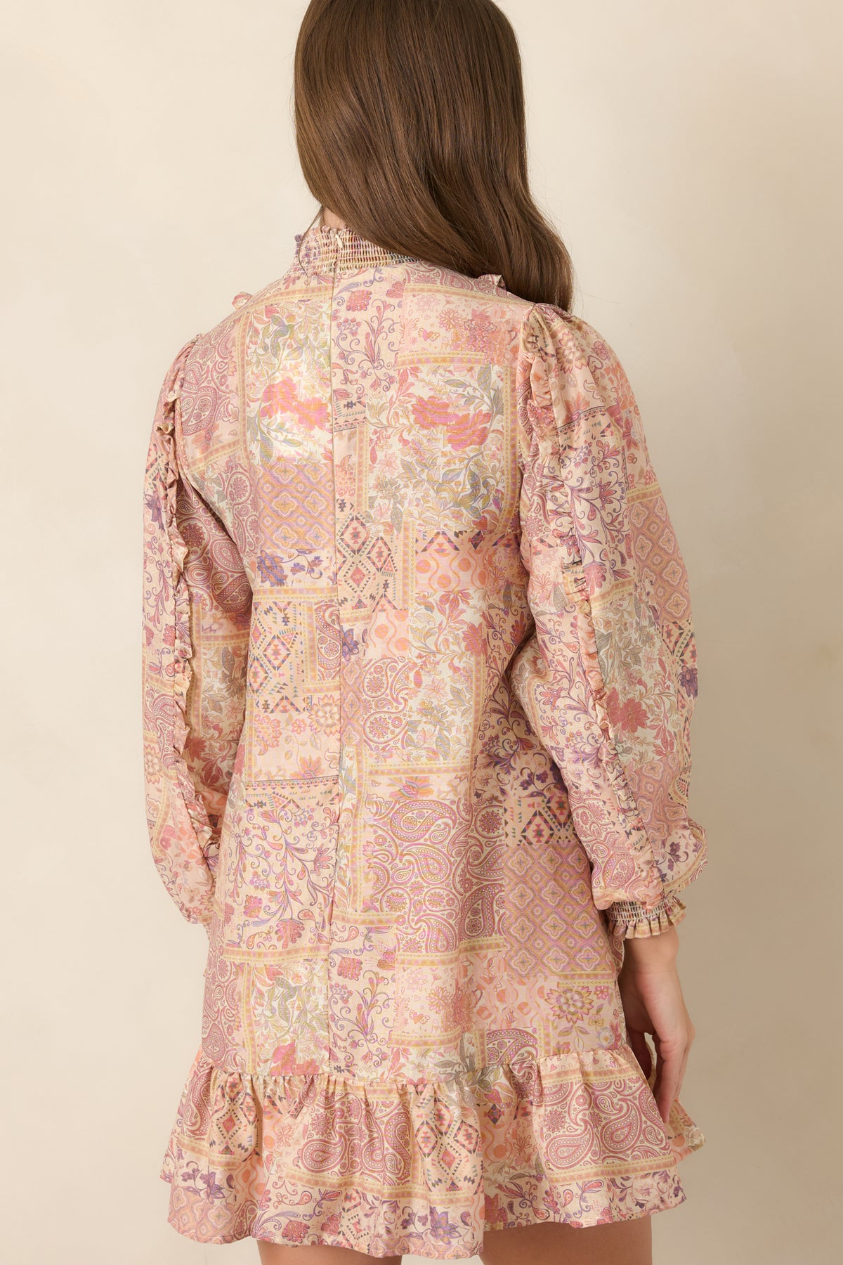 Rear of printed mini dress showing relaxed shift silhouette and ruffle hem.