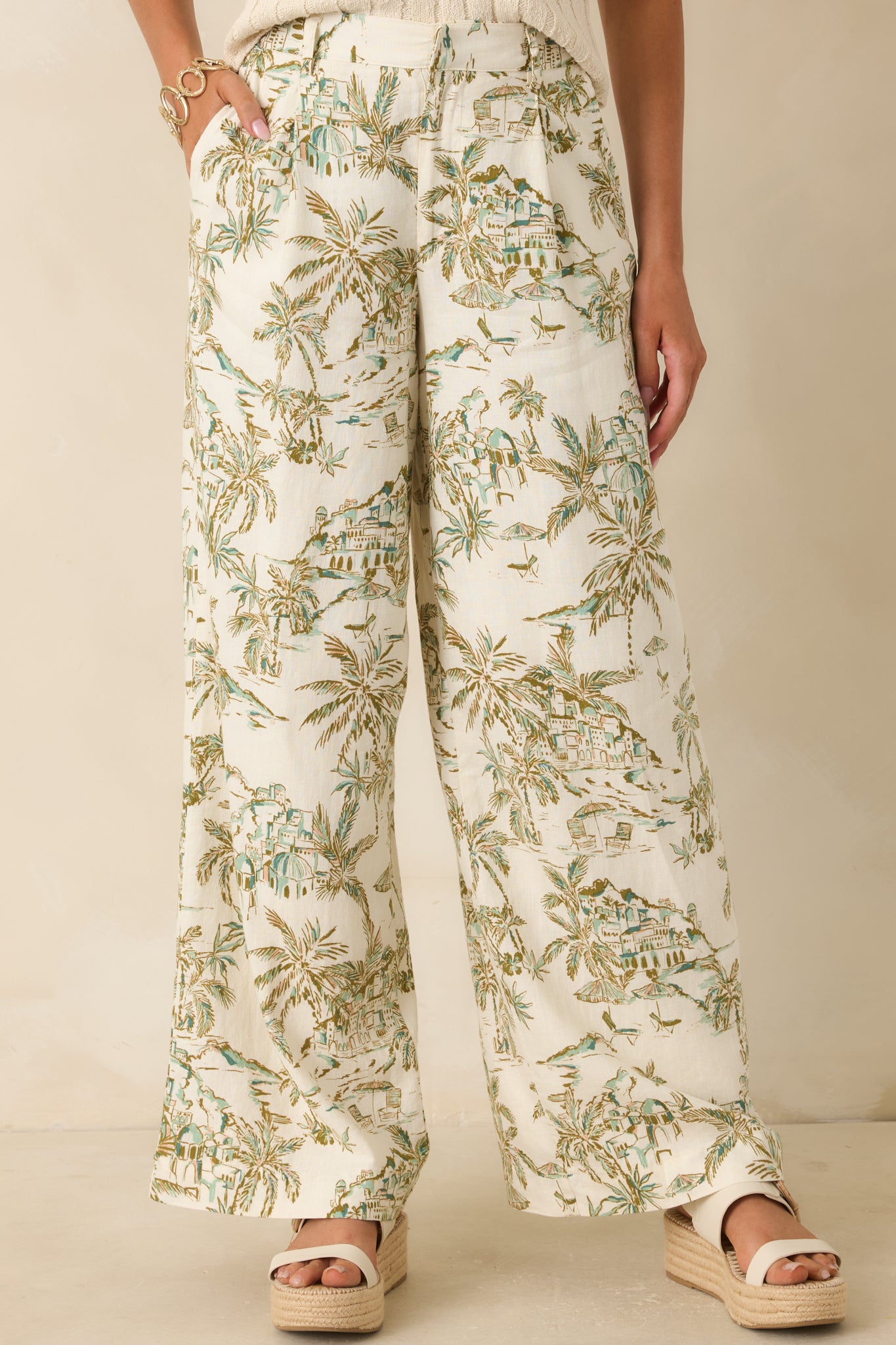 Printed pants featuring side seam pockets and soft washed texture in beige and green tones.