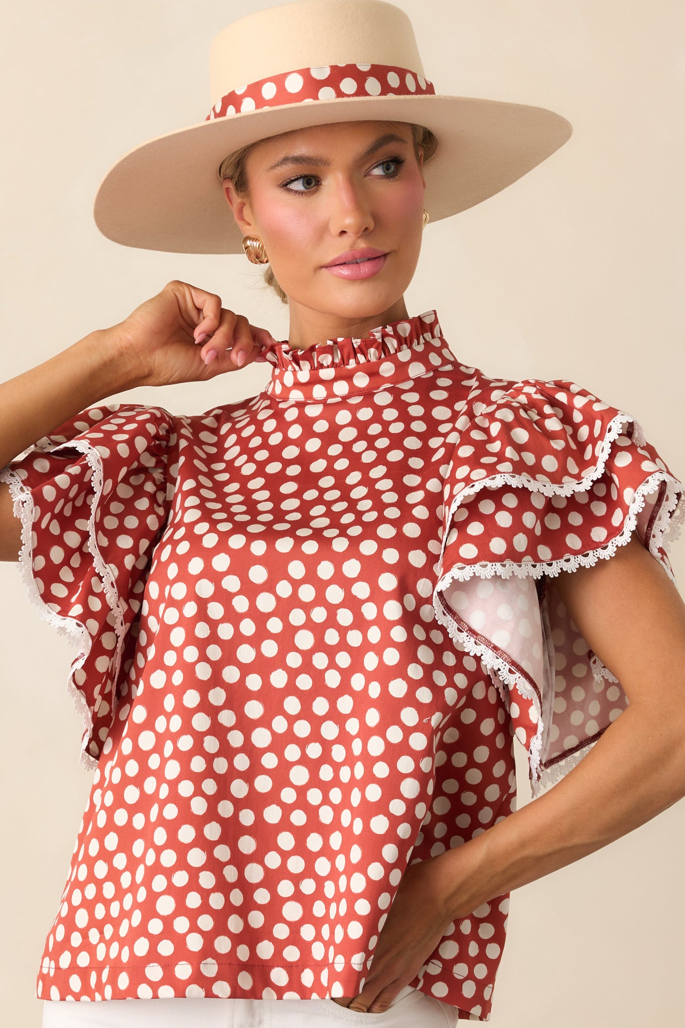 Close view of the polka dot top highlighting the ruffle mock neckline and trim